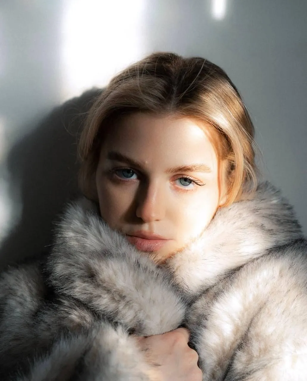 Woman Wrapped in a Fur Coat Looking Confidently at Camera