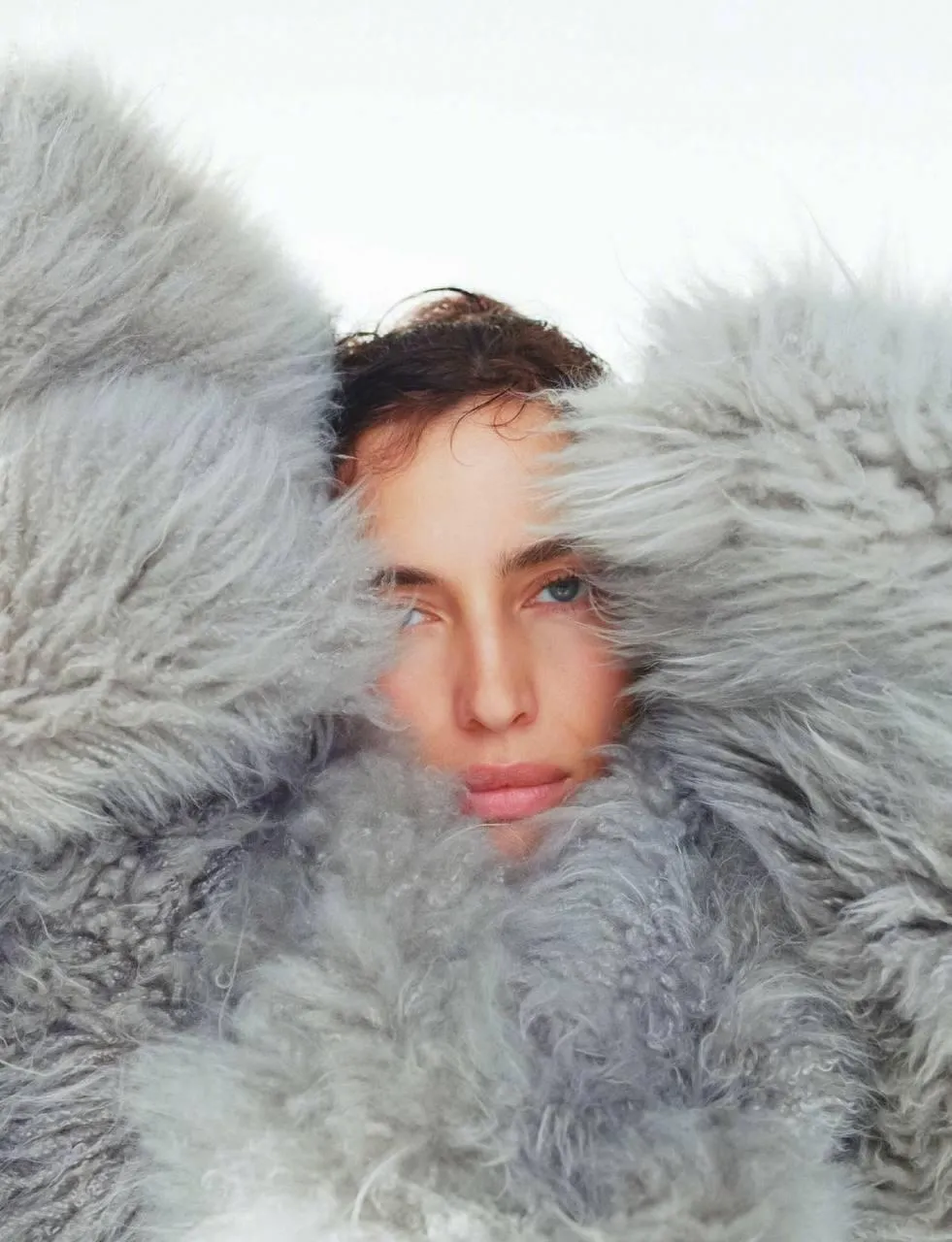 Woman Wrapped in a Oversized Fluffy Coat with Serious Look