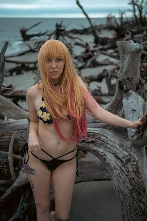 Young woman in a bikini standing near the dry tree wallpaper