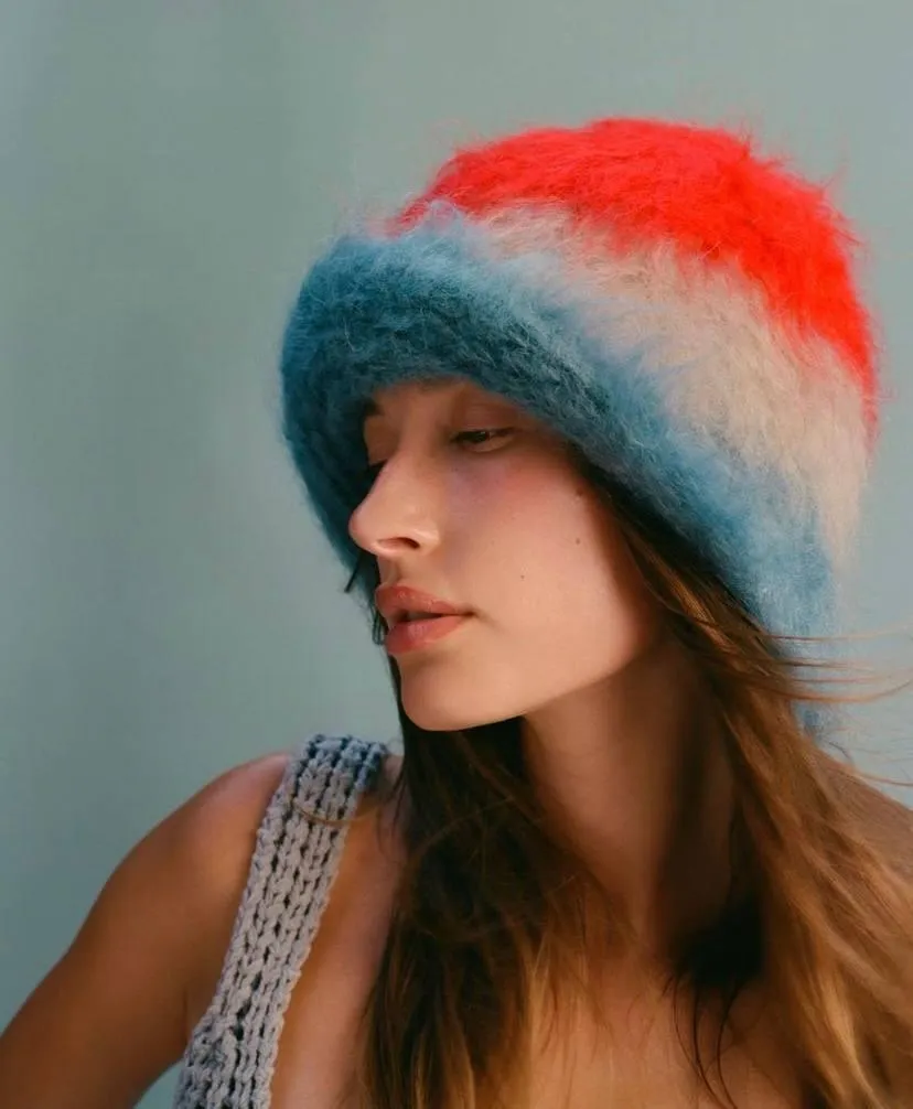 Young woman in a colorful hat looking to the side HD image