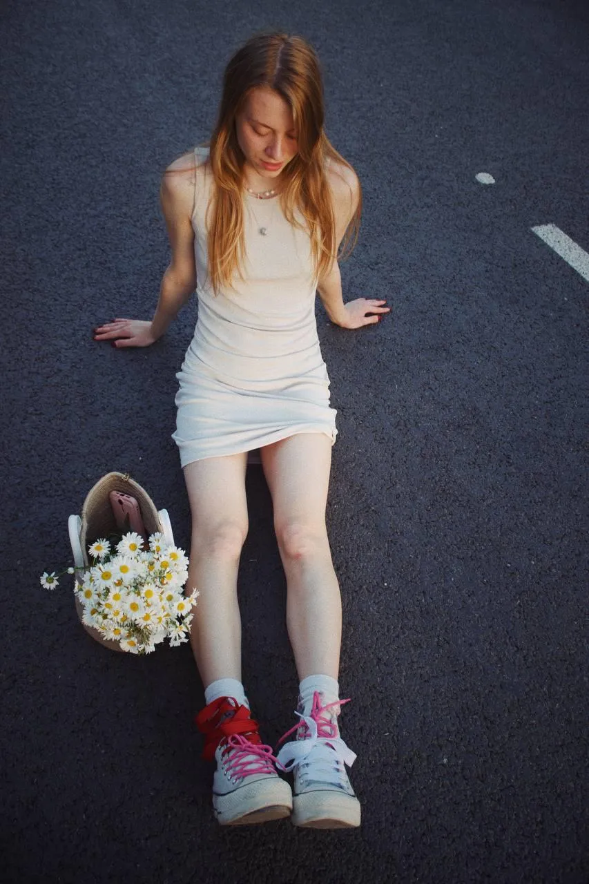 Young Woman in a White Dress Standing on Road Holding Basket