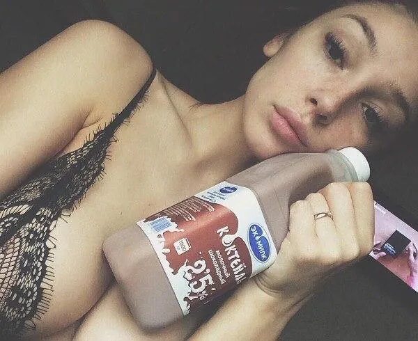 Young woman wearing black lingerie holding a bottle image