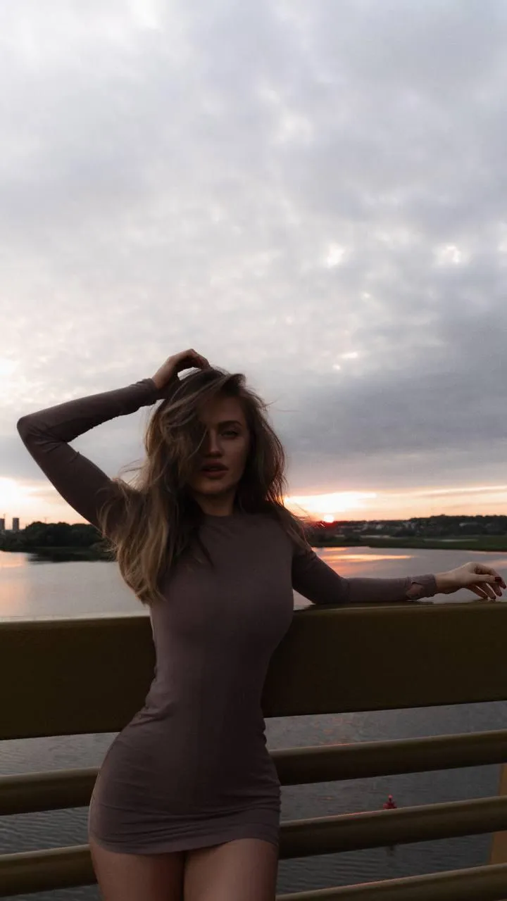 Young woman with a gray bodysuit with a lake and sunlight
