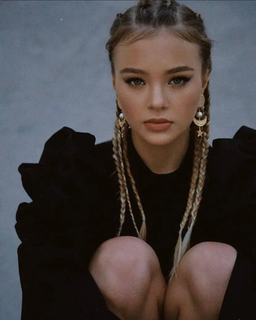 Young woman with braided hair and gold earrings HD Wallpaper