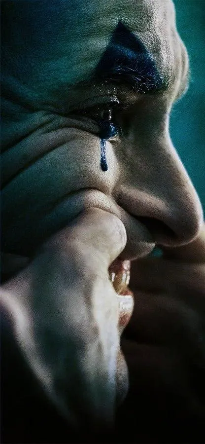 Emotional Joker Close Up Side Look with Tear on Pale Cheek