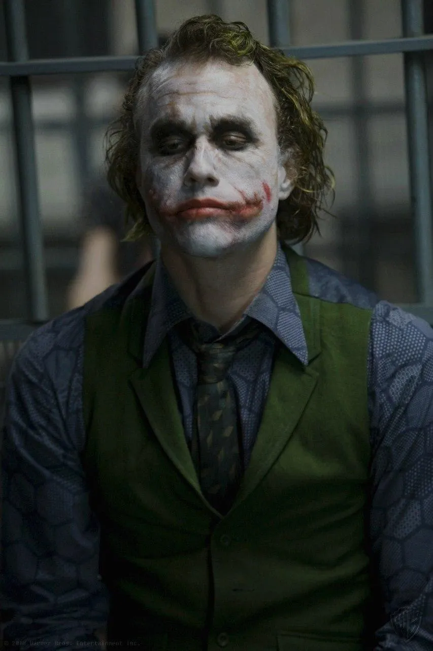 Joker in Green Vest Staring Ahead with Cold Eyes Wallpaper