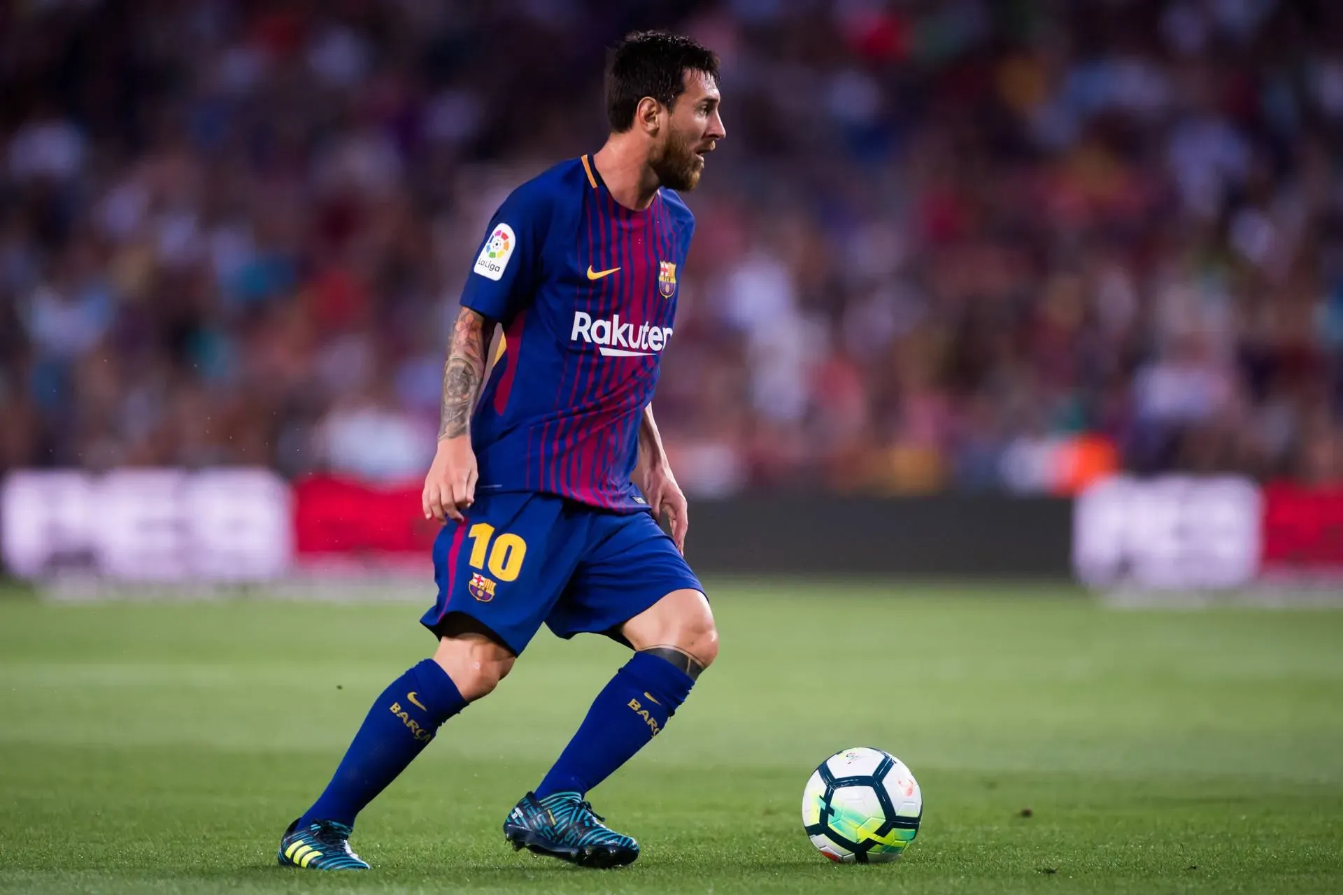 Lionel Messi In Barcelona Jersey Playing Football Wallpaper