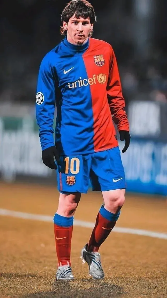 Young Lionel Messi With Cute Expression on Ground Wallpaper