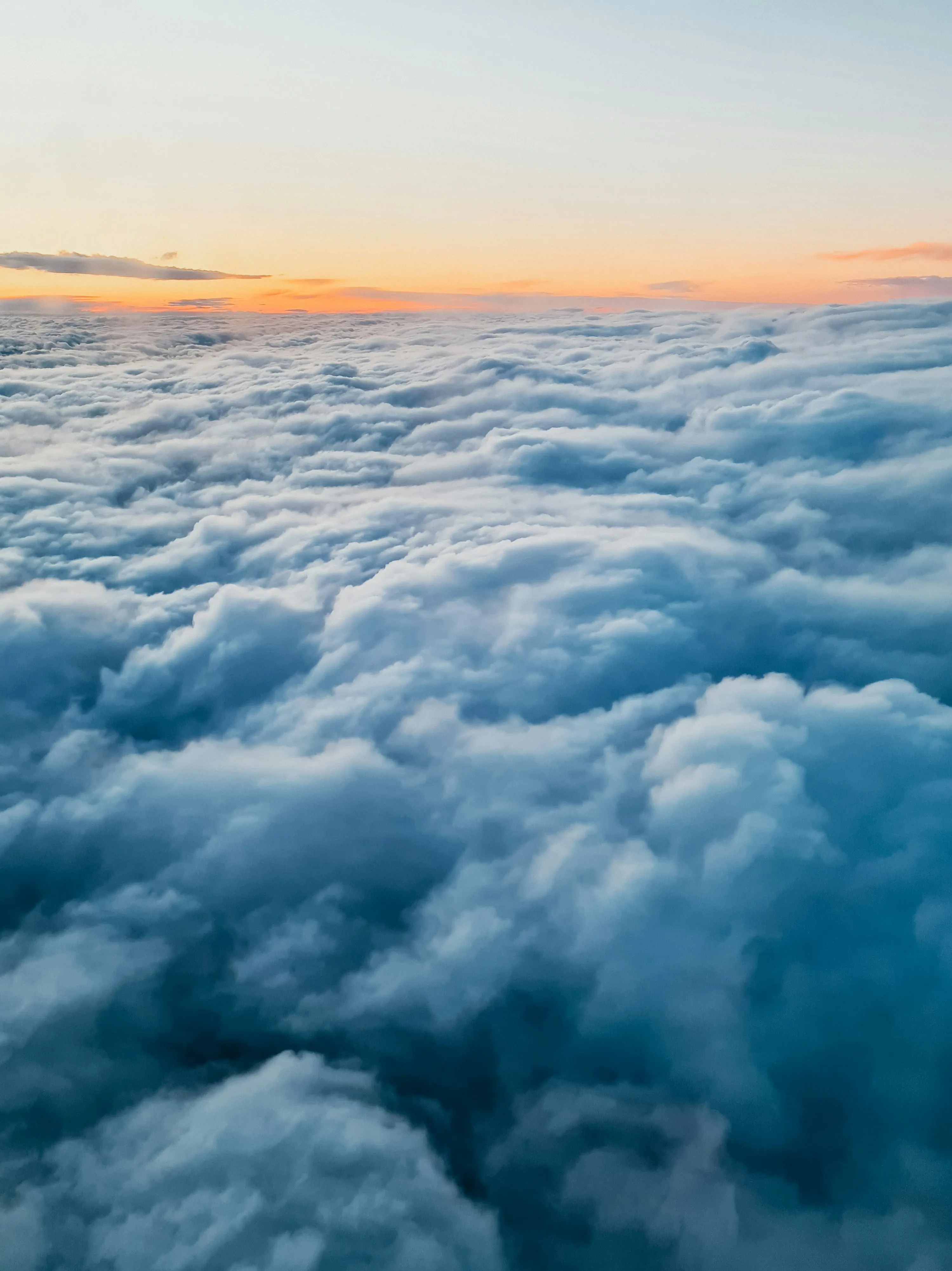 Aerial View of Dense Clouds at Sunrise Over Mountains