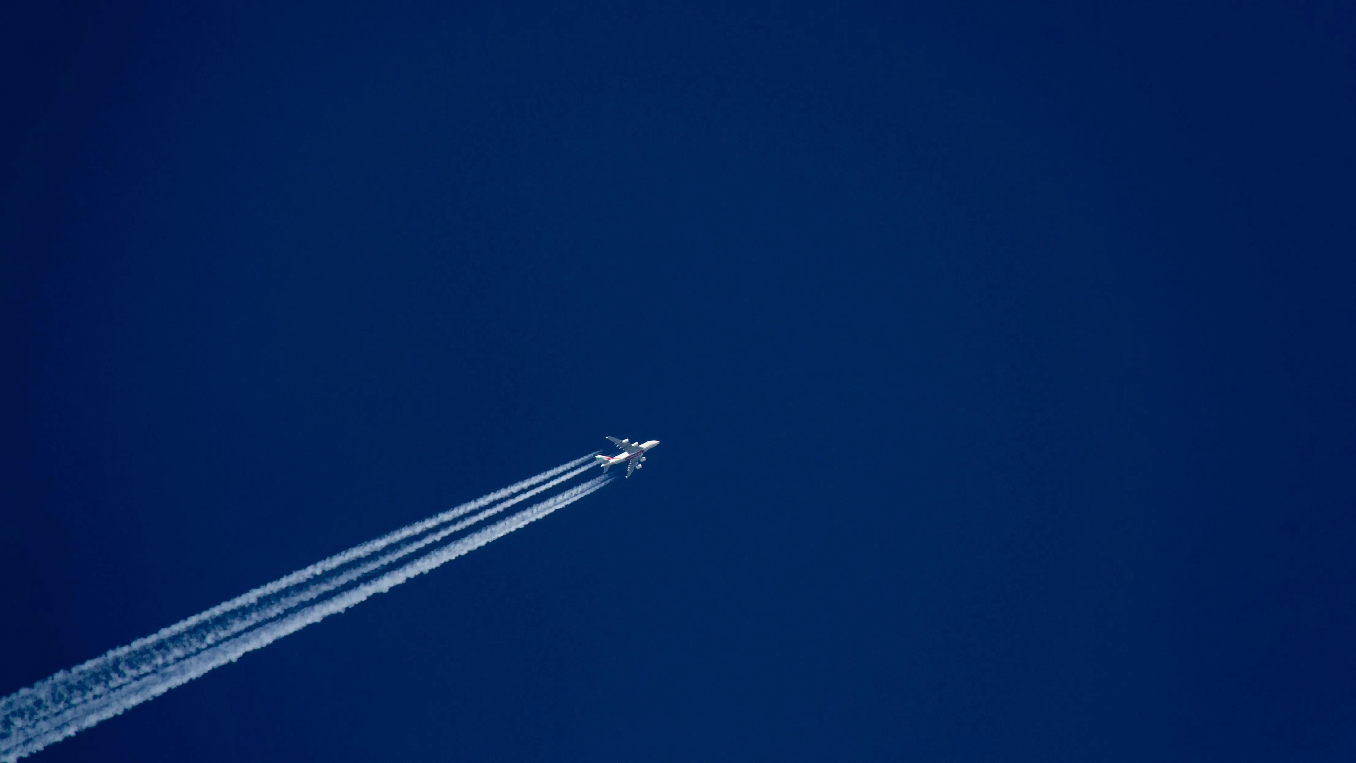 Airplane Contrail Against Deep Blue Clear Sky at Dusk
