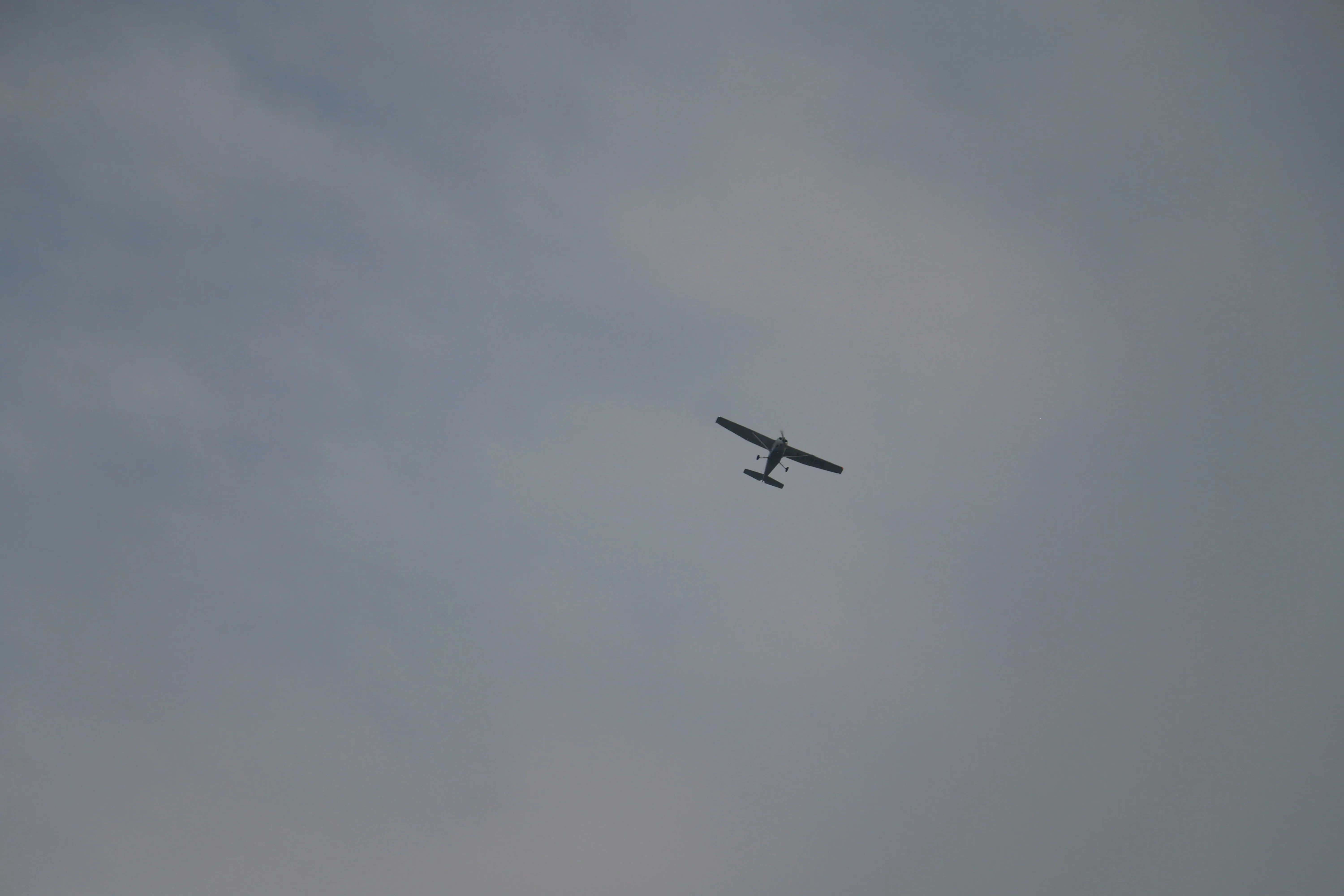 Airplane Flying Through Misty Sky with Gray Clouds