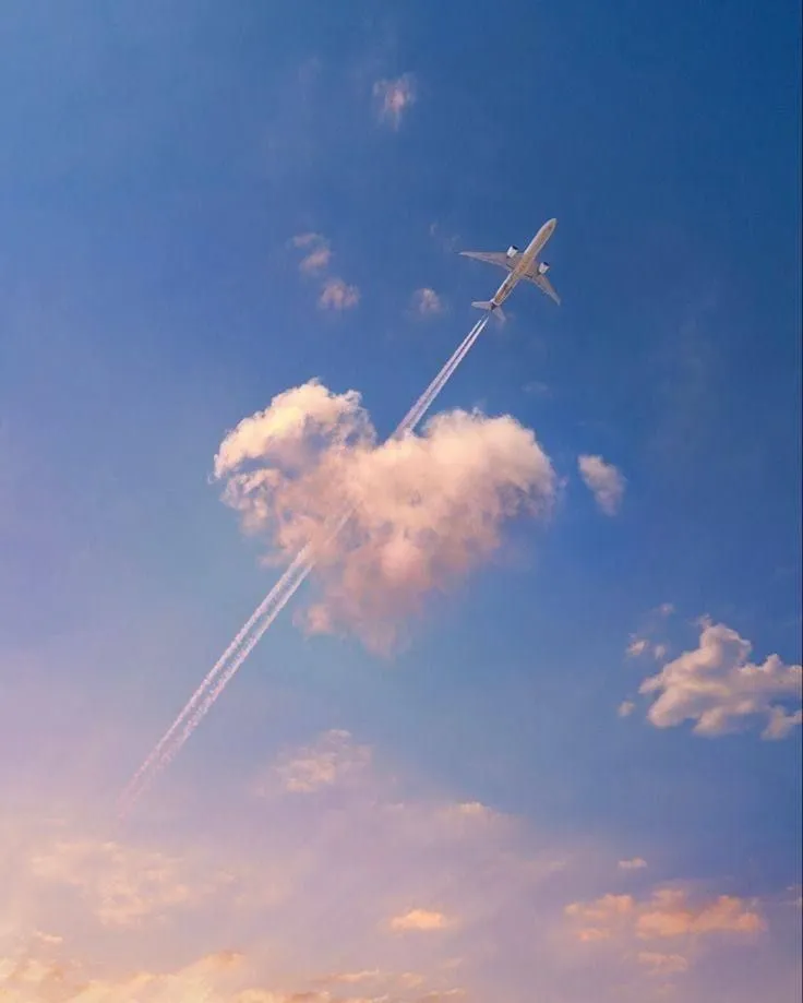 Airplane Trails Cross Through Vibrant Sunset Clouds Image