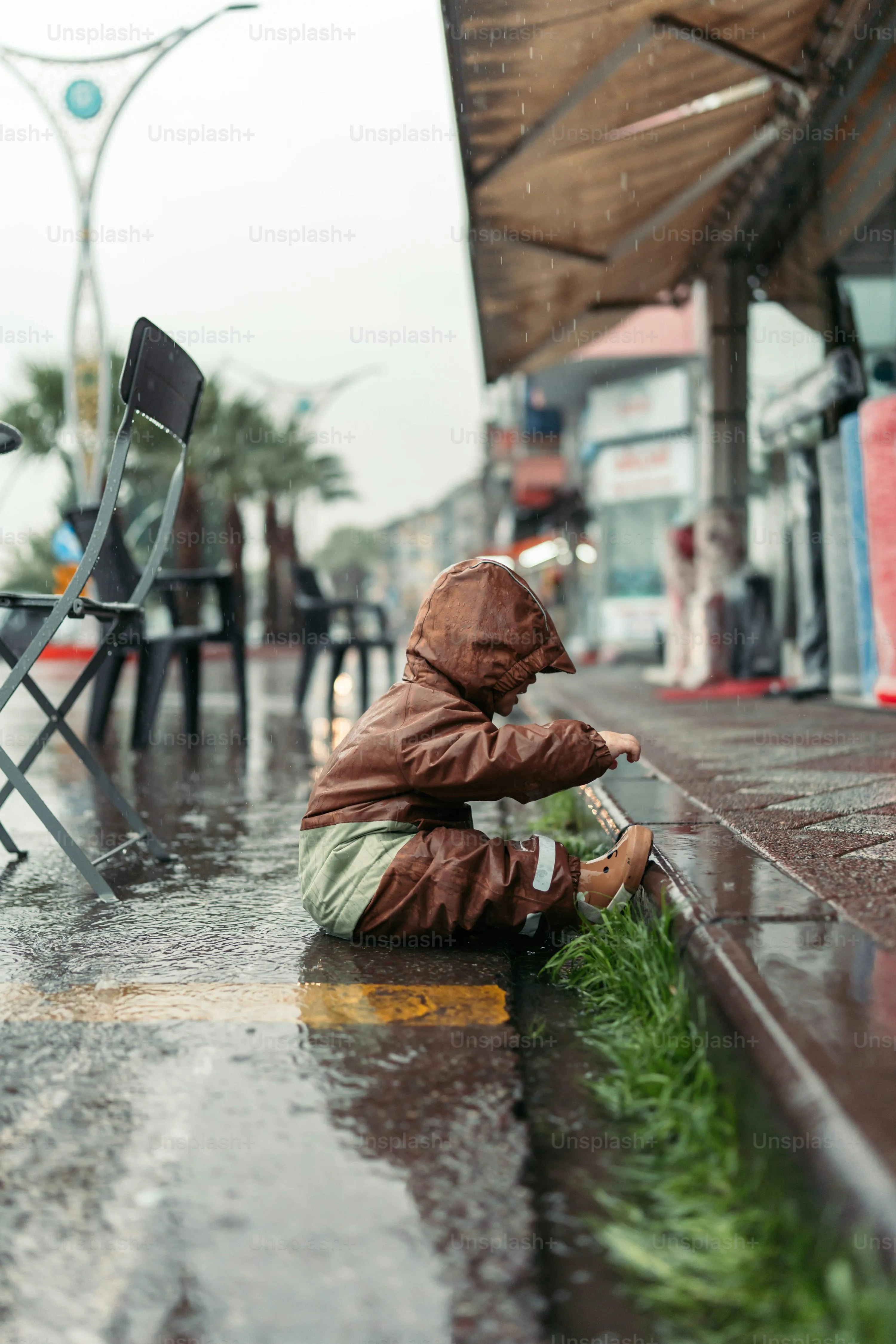 Baby Sitting in The Rain Near Urban Street Scene Wallpaper
