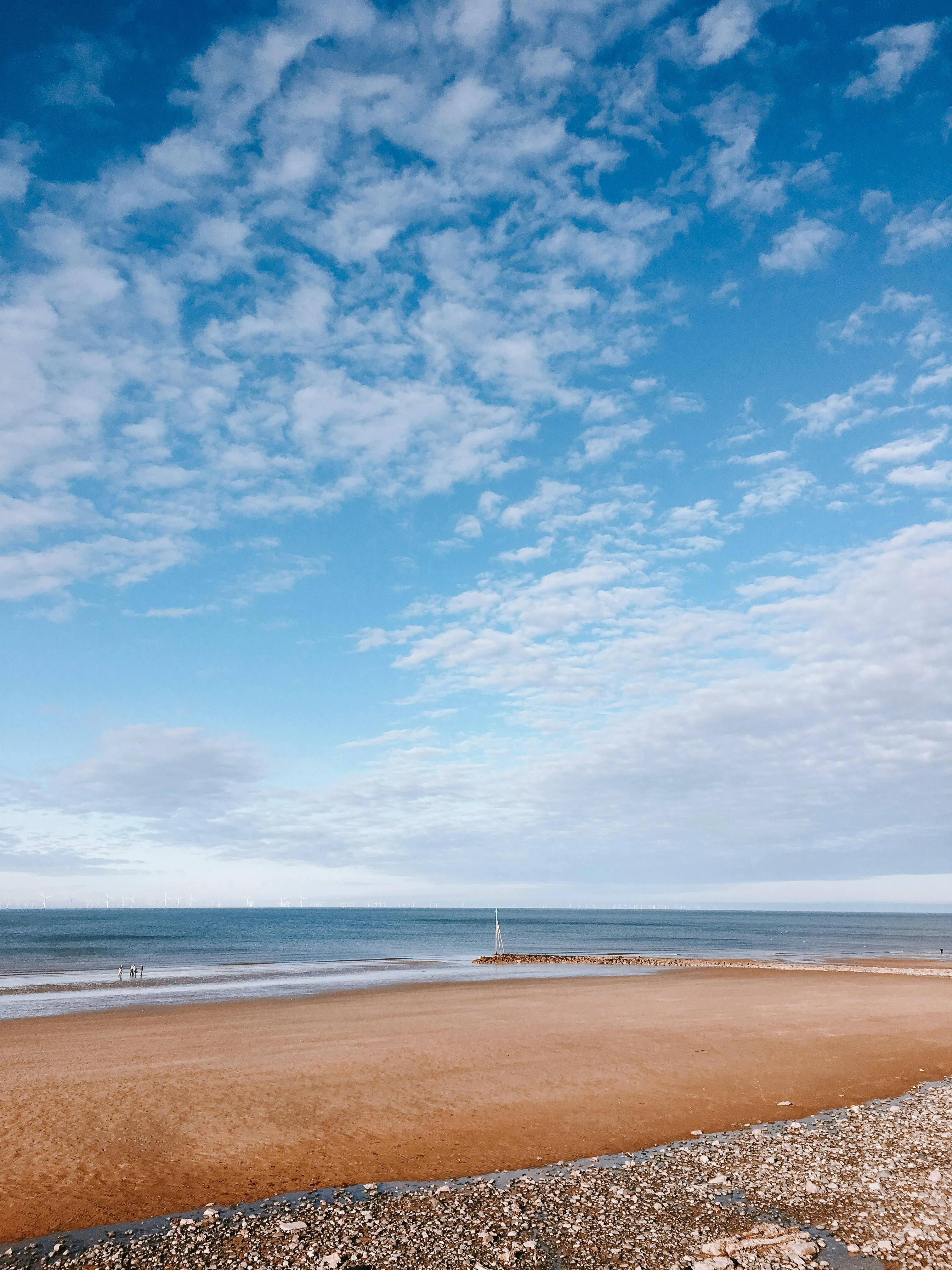 Beach Scene with Blue Sky and White Clouds Stretching Far