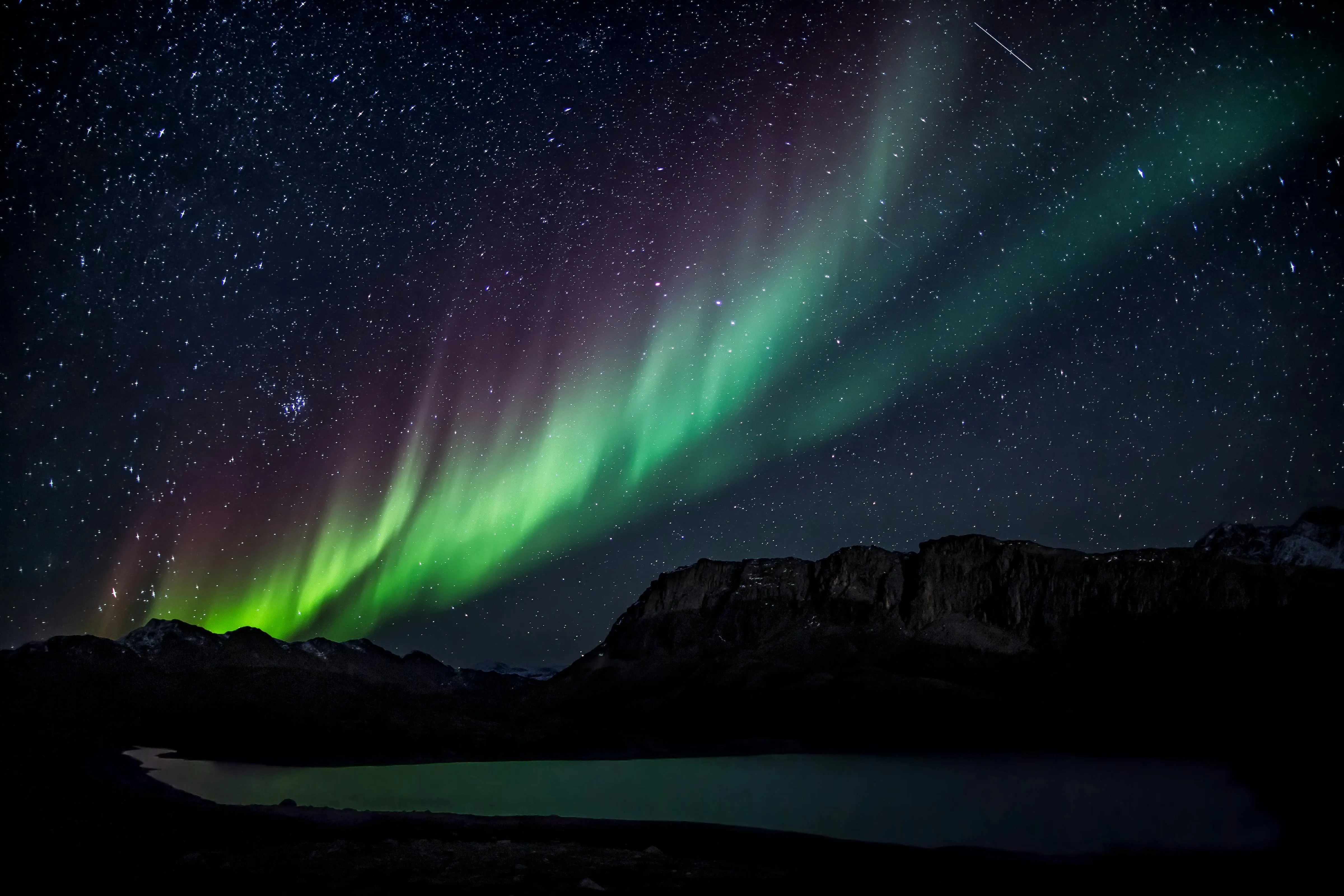 Beautiful Northern Lights Over Dark Mountain Silhouettes