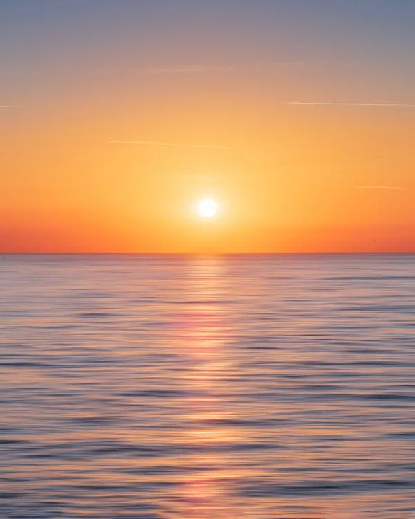 Beautiful Sunrise Over Calm Ocean with Smooth Water