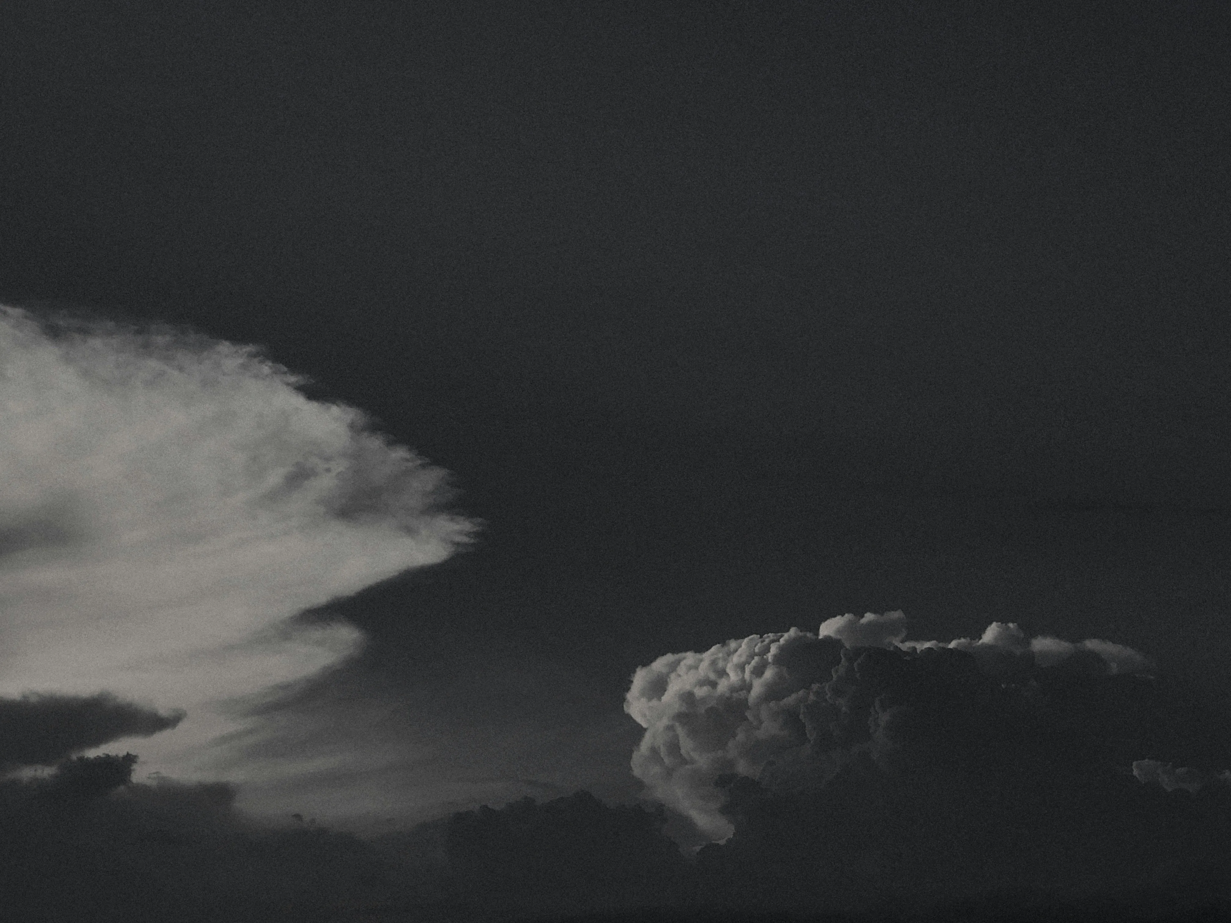 Black and White Cloud Formations Over a Calm Sea Wallpaper