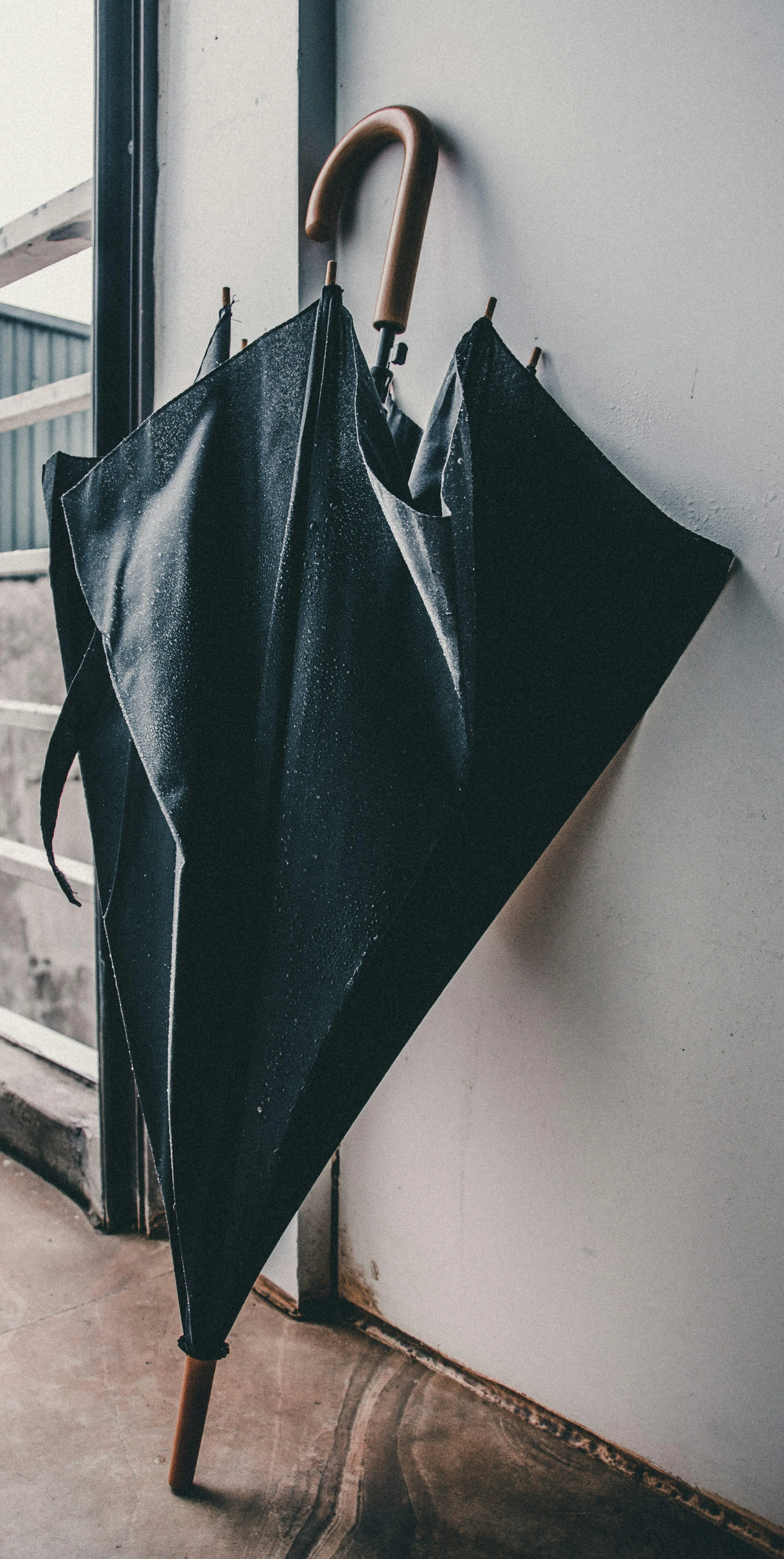 Black Umbrellas Leaning on Wall After Rainy Day Outdoors
