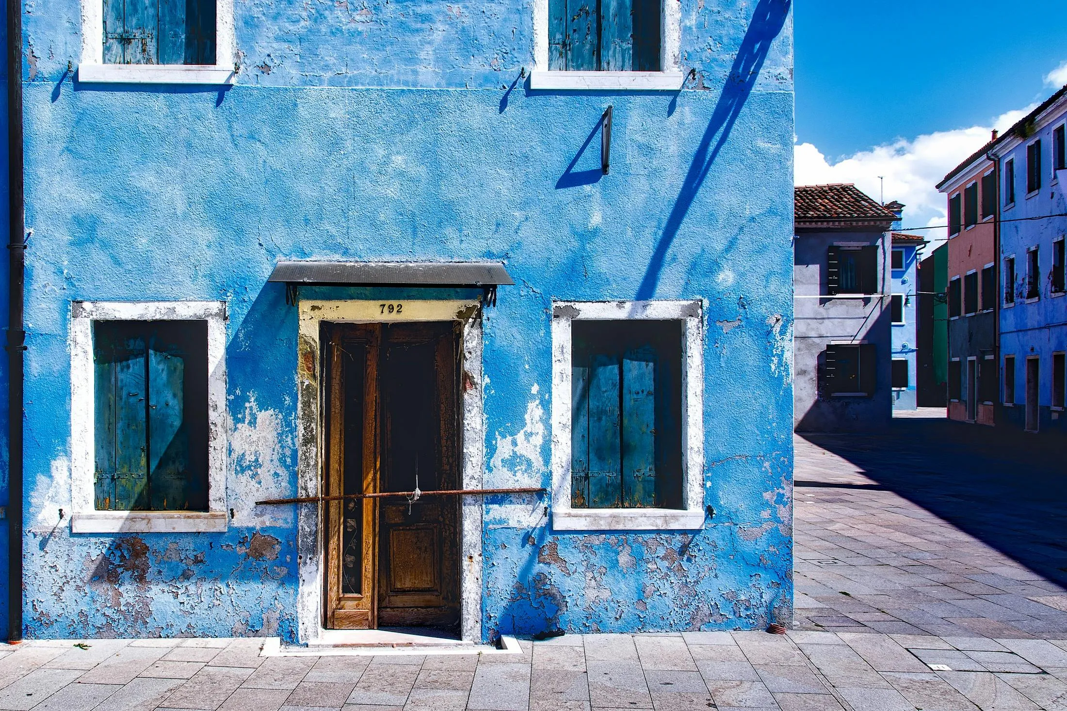 Blue House with White Trim Under Clear Cloudy Sky Image