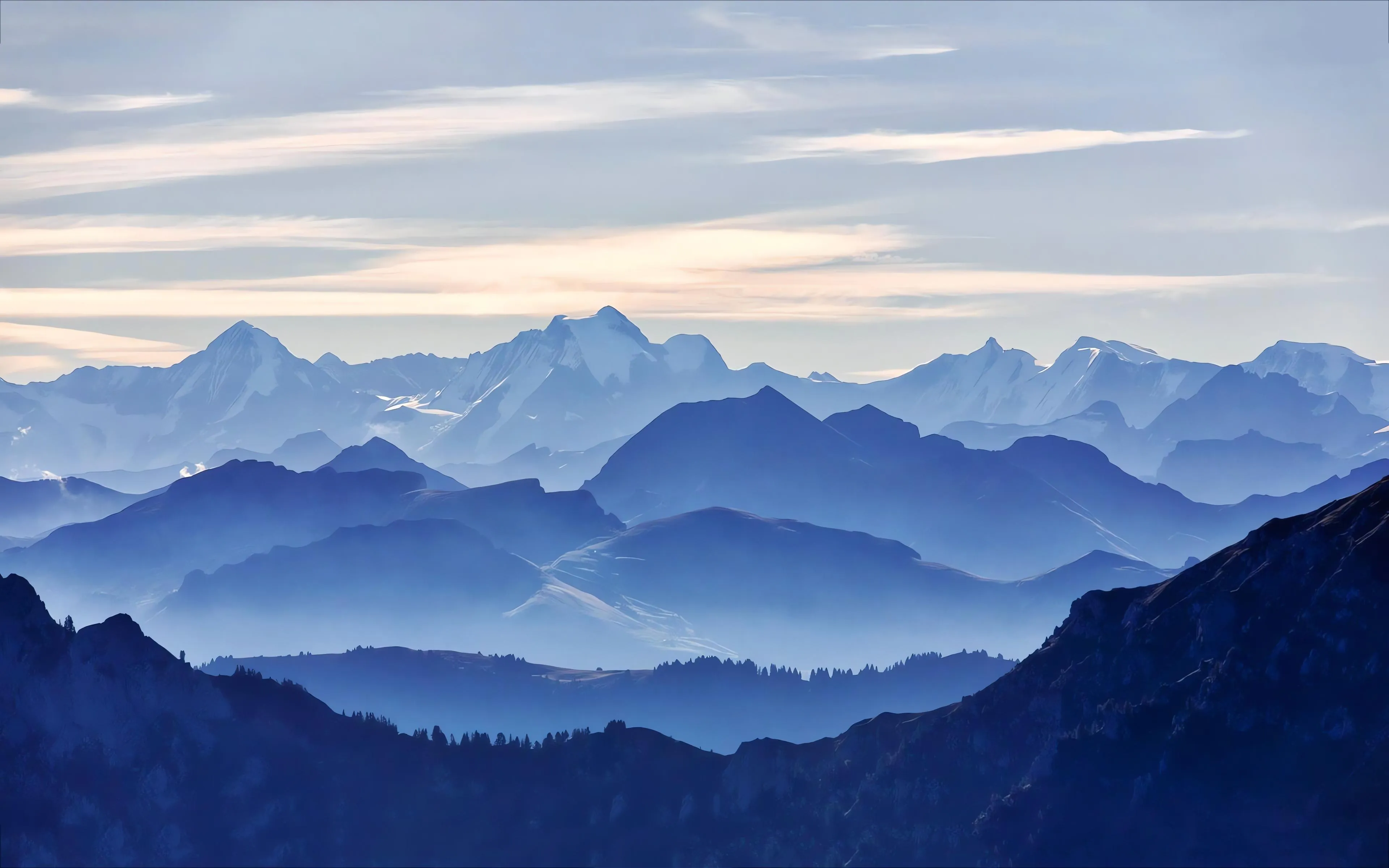 Blue mountain range with misty clouds at sunrise Wallpaper