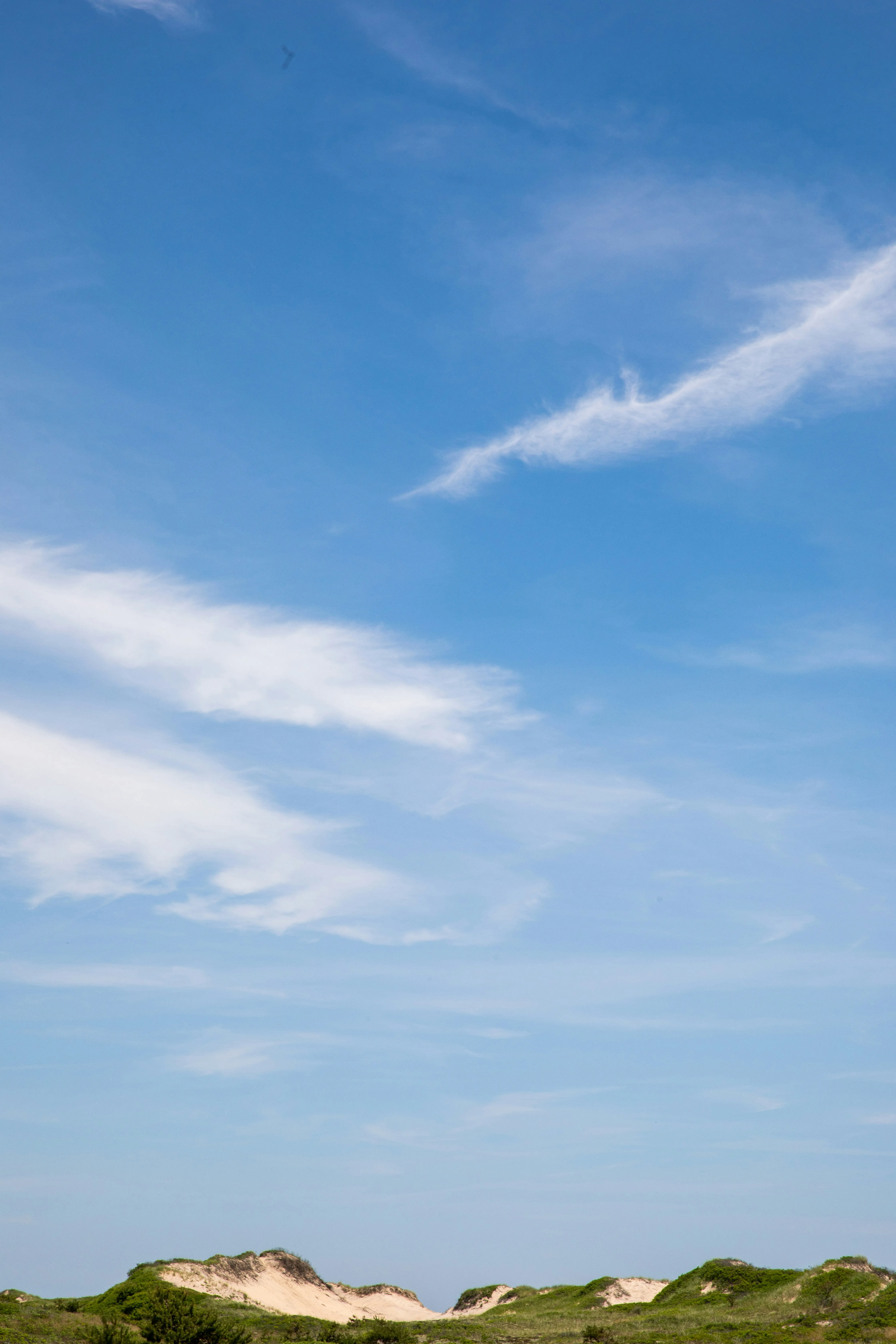 Blue Sky and Wispy Clouds Above a Peaceful Beachfront