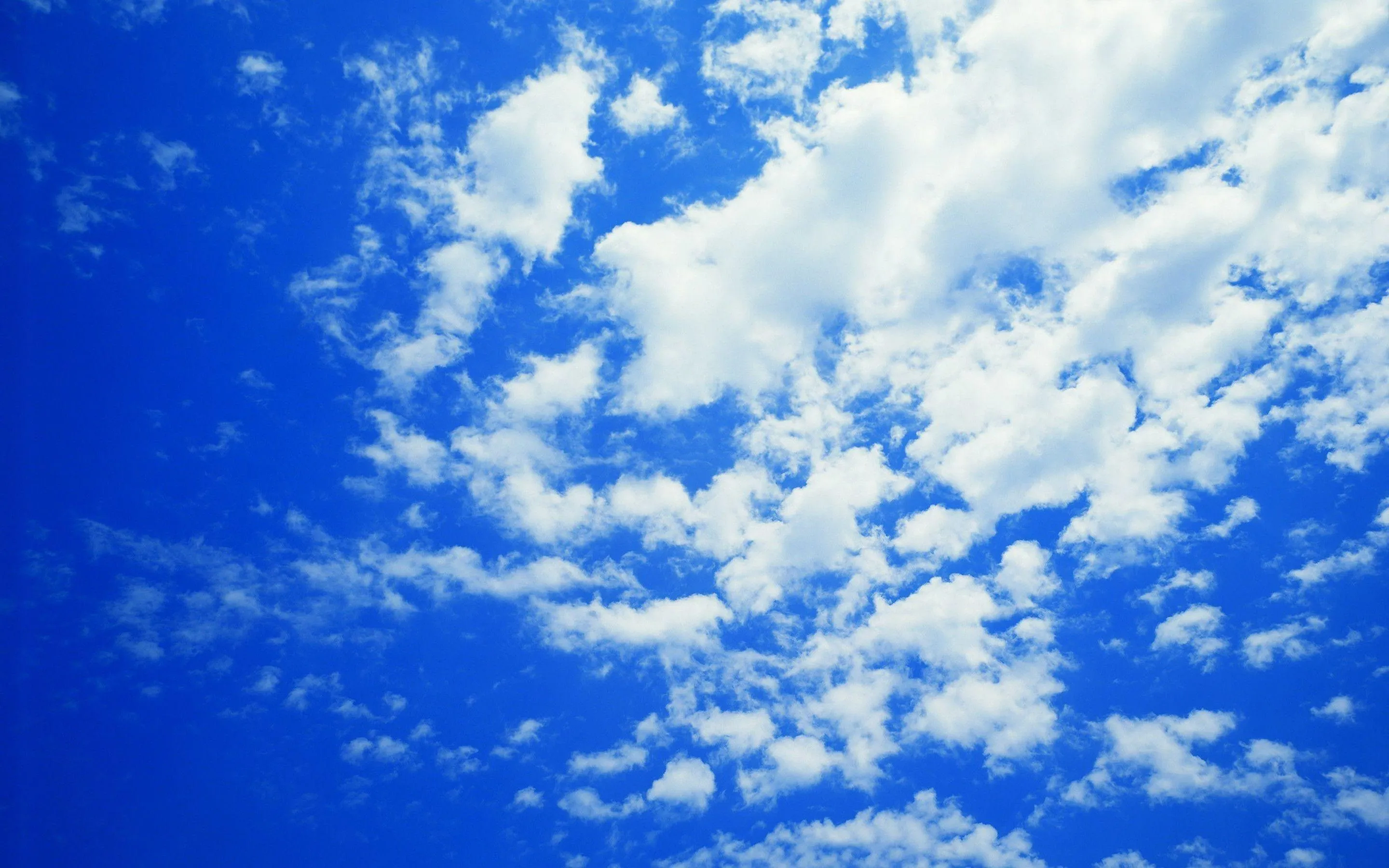 Blue Sky Filled with Scattered White Fluffy Clouds Wallpaper
