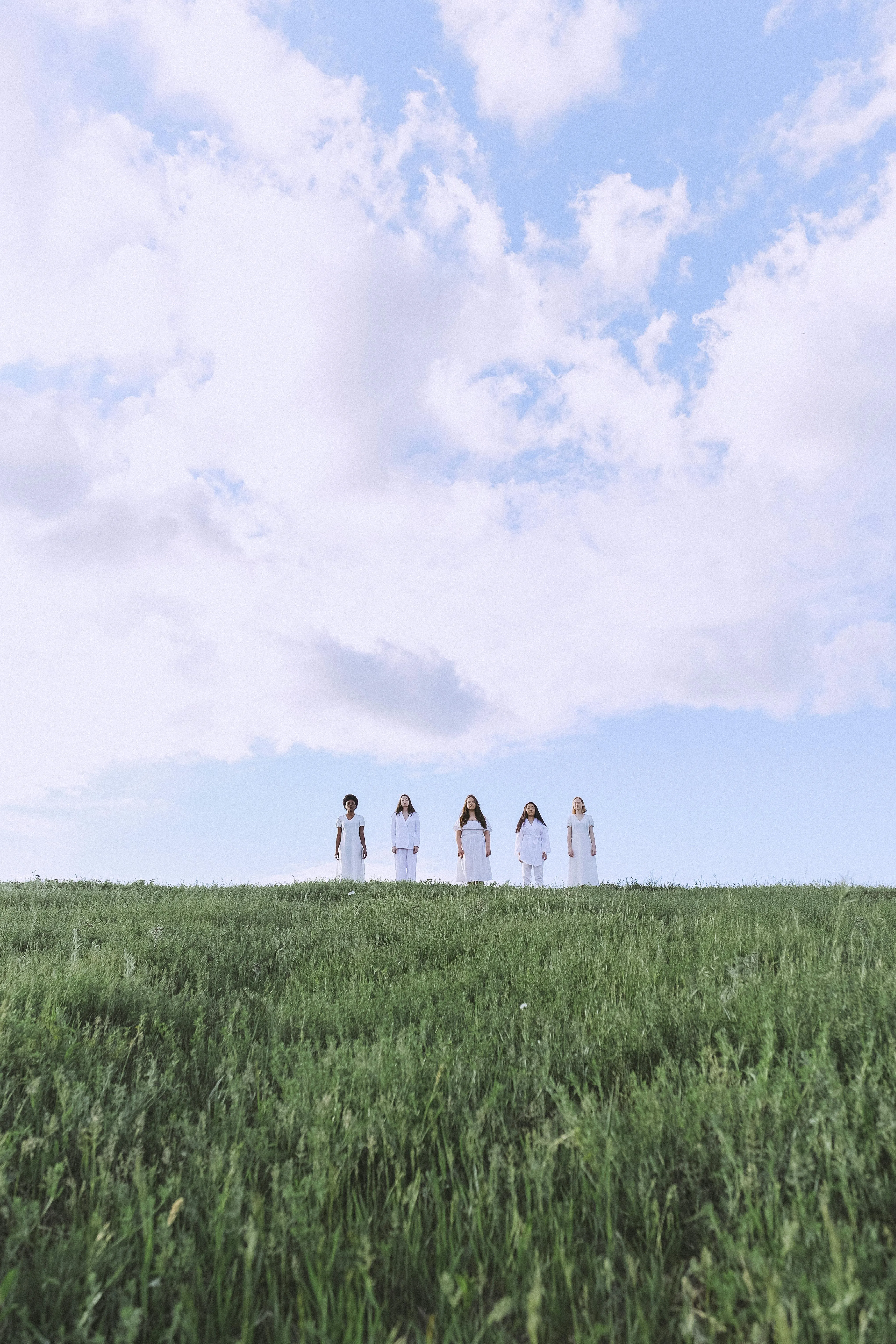 Blue Sky Over Green Field with Distant Children Standing