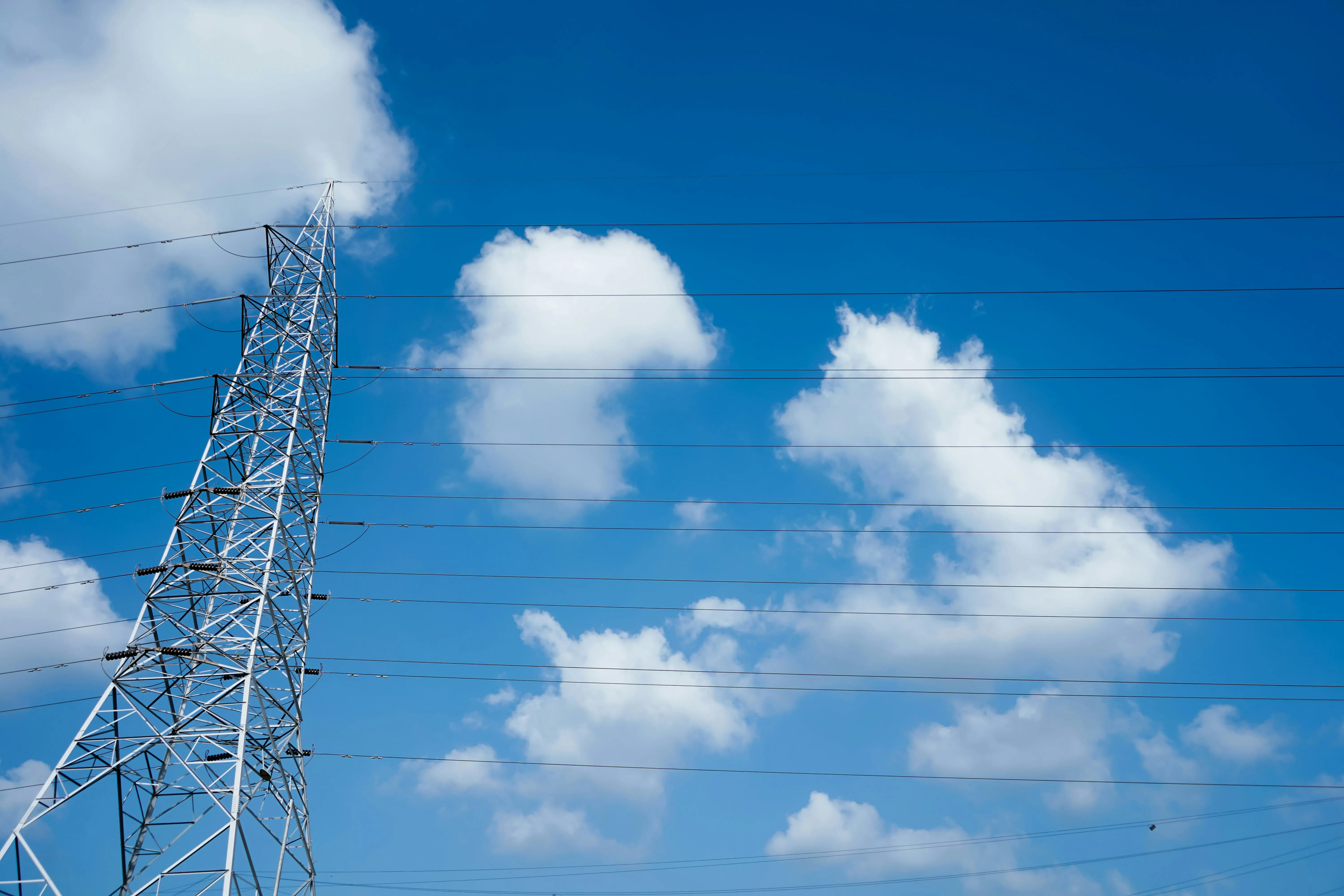 Blue Sky with Puffy White Clouds and Transmission Tower