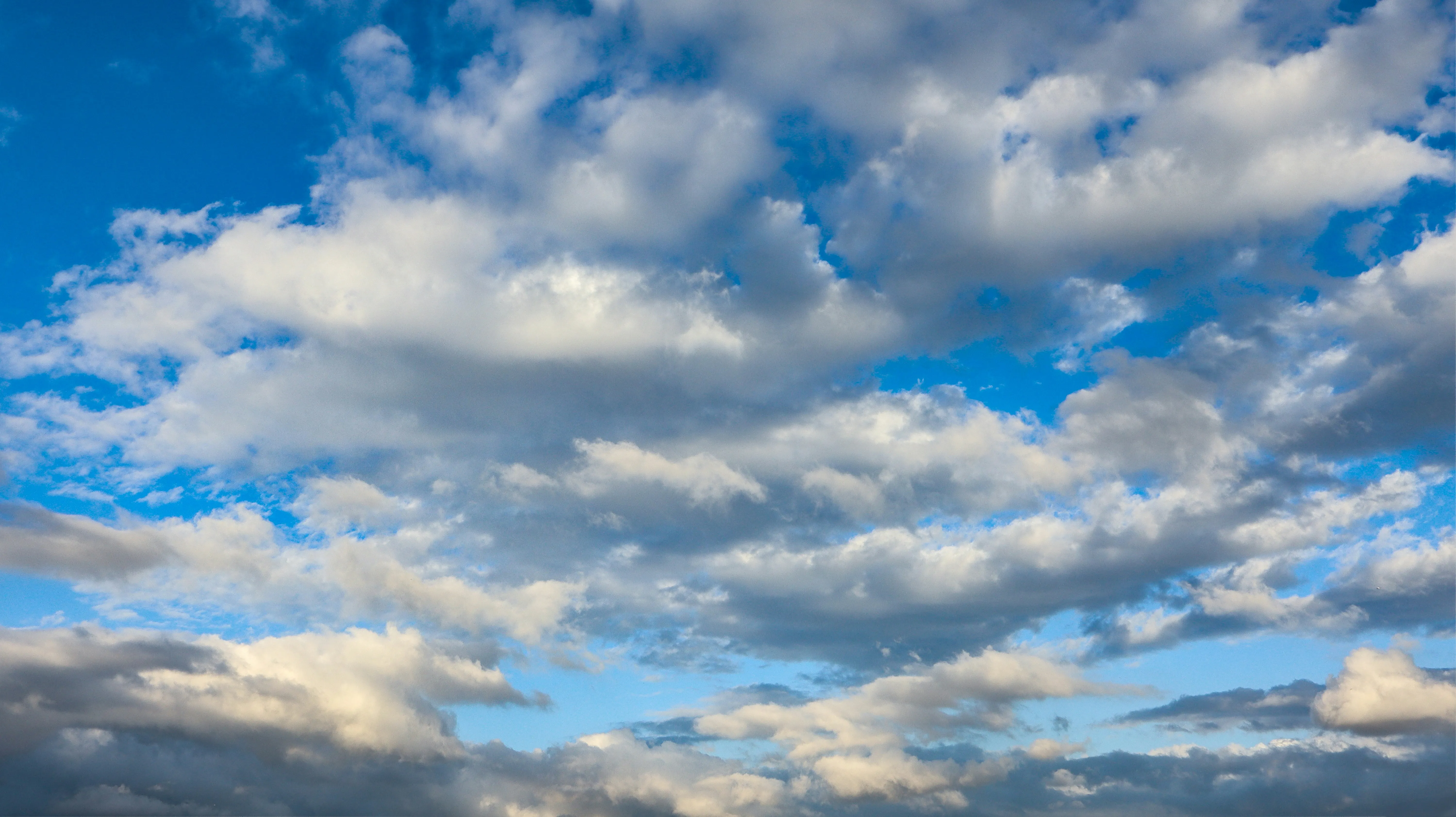 Blue Sky with White Puffy Clouds Over Open Landscape