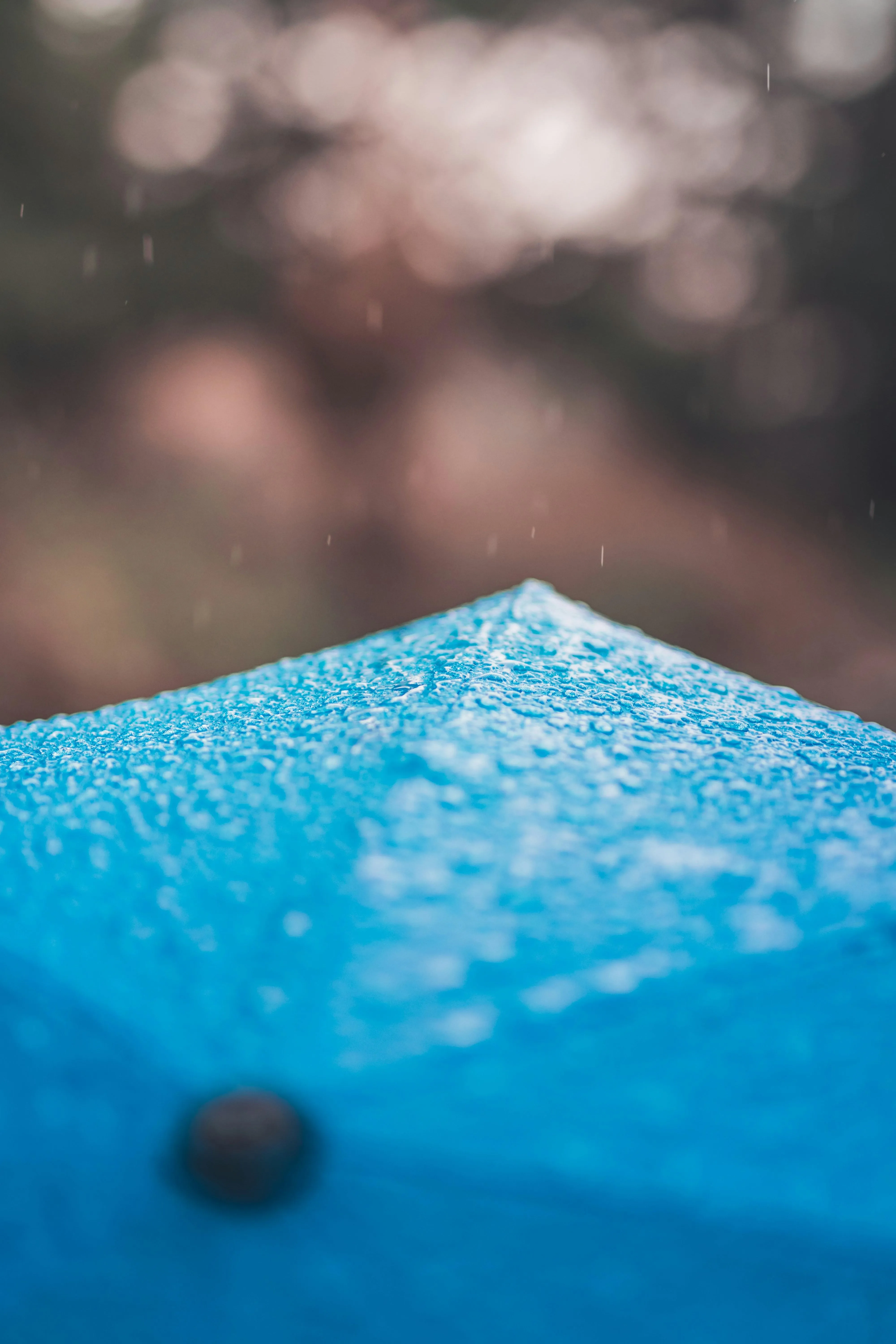 Blue Umbrella with Water Droplets Captured Close Up