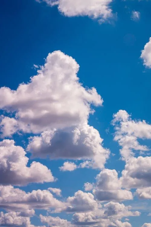 Bright Blue Sky Filled with Large Cumulus Clouds Wallpaper