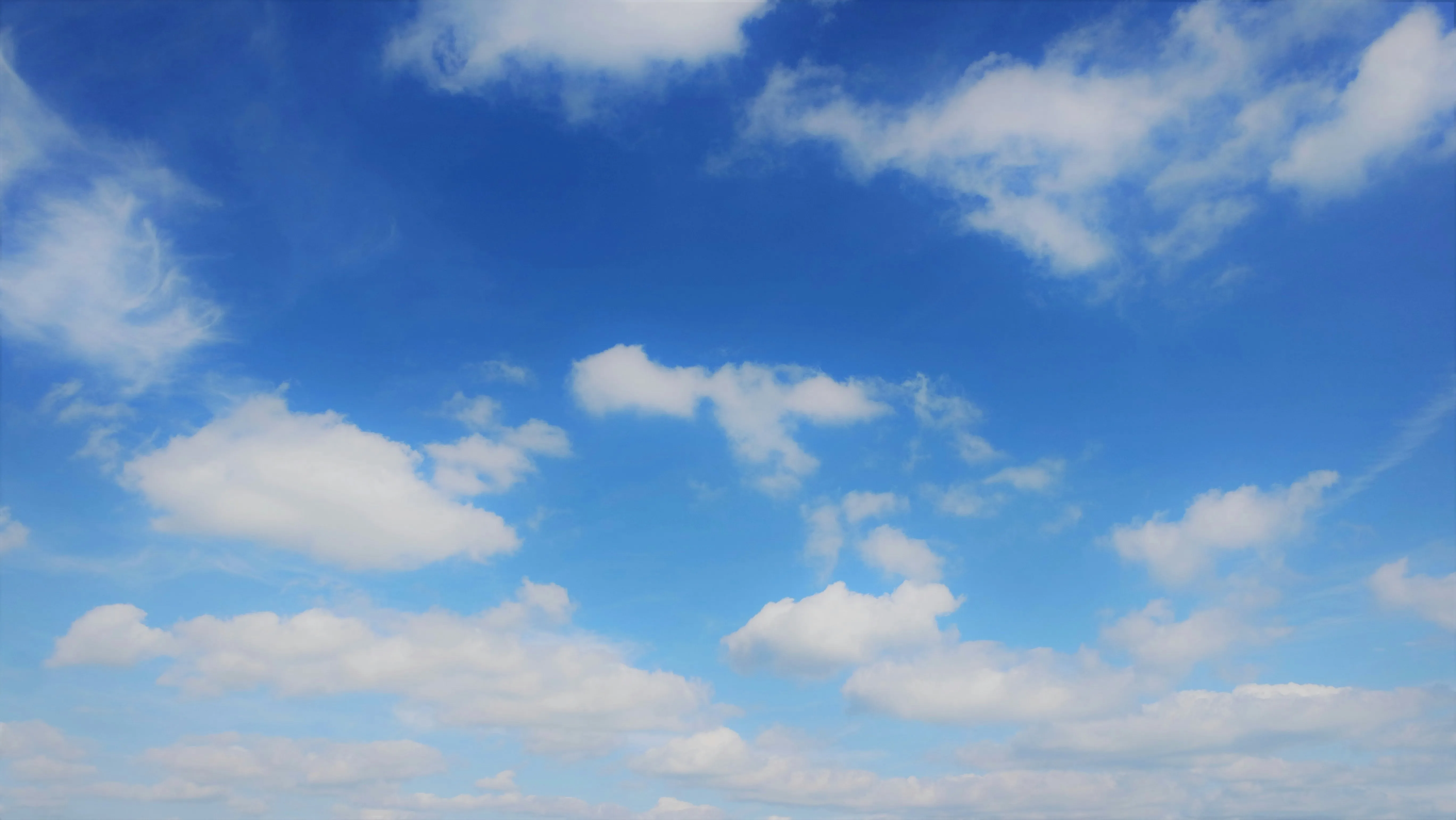Bright Blue Sky Filled with Puffy White Clouds Scattered