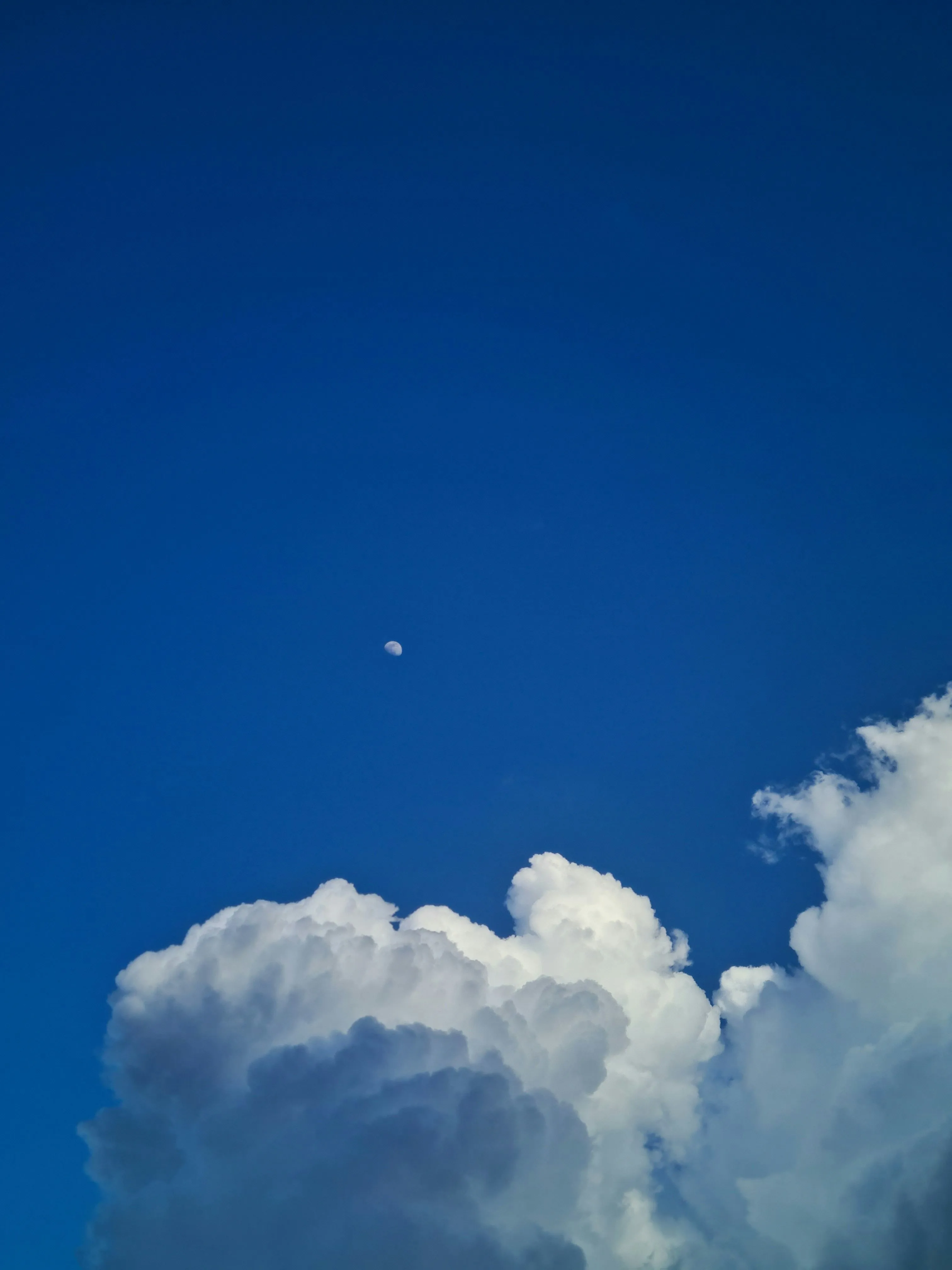 Bright Blue Sky with Fluffy White Clouds and Moon Image
