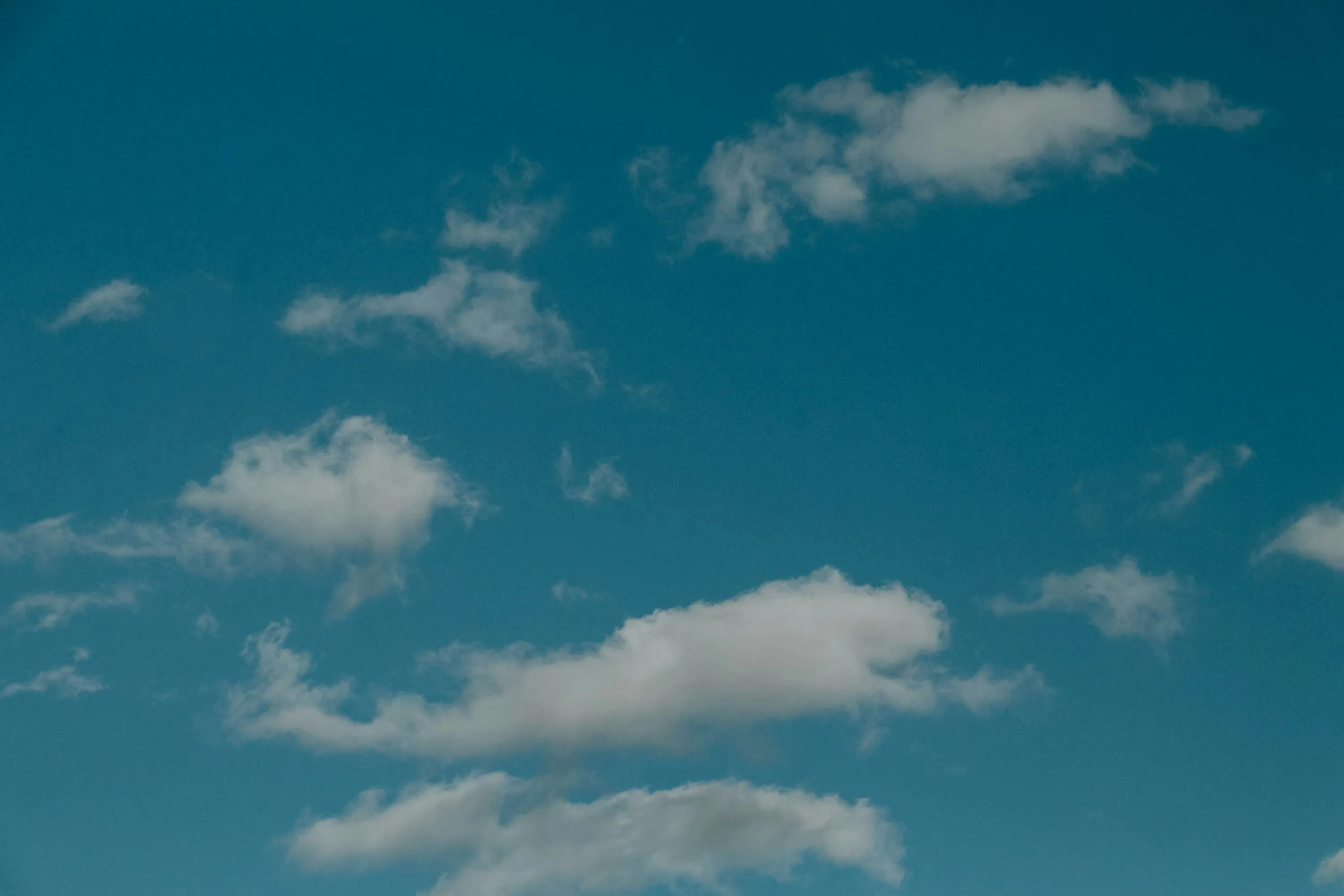 Bright Blue Sky with Minimal Scattered White Clouds