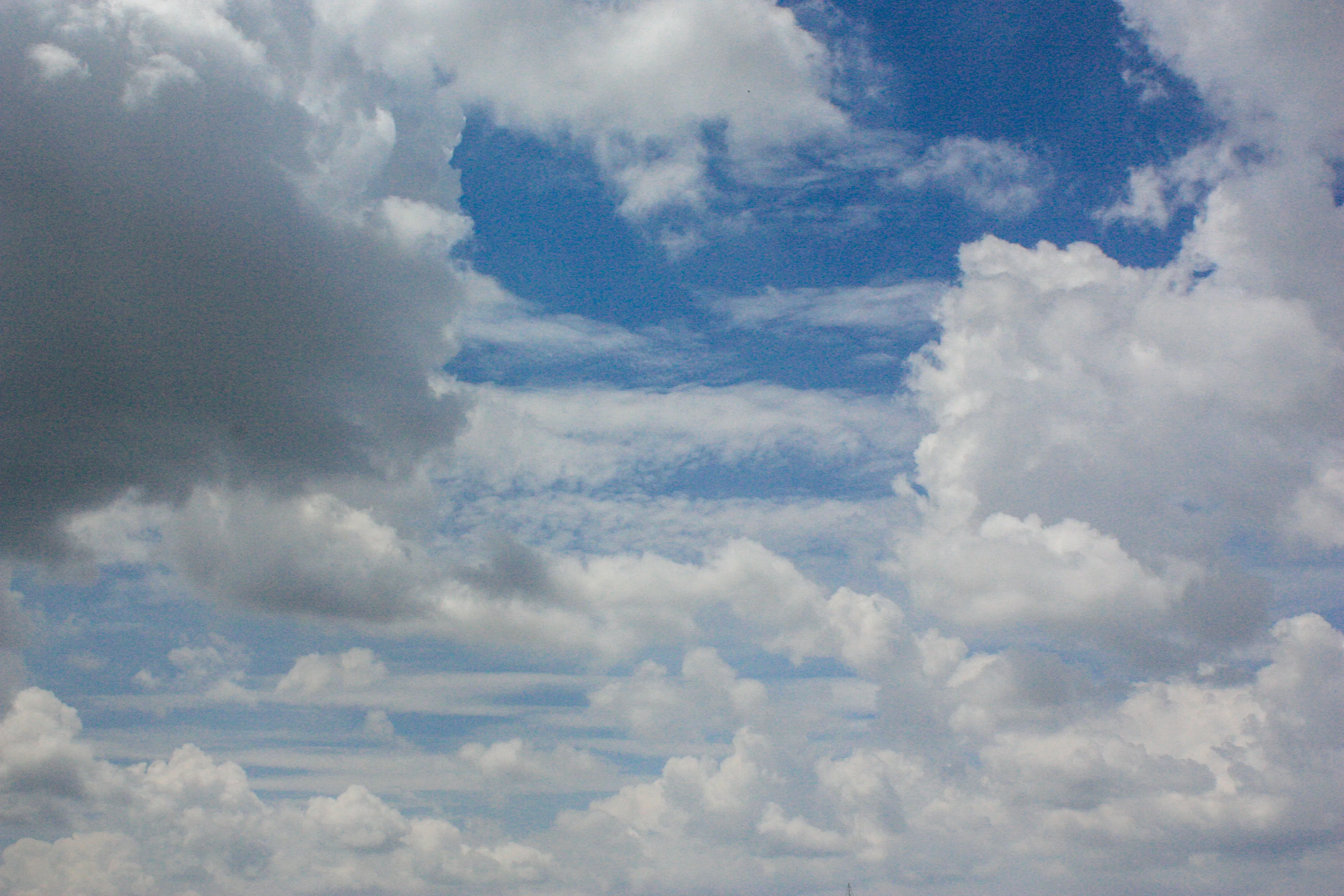 Bright Blue Sky with Puffy Clouds and Soft Sunshine