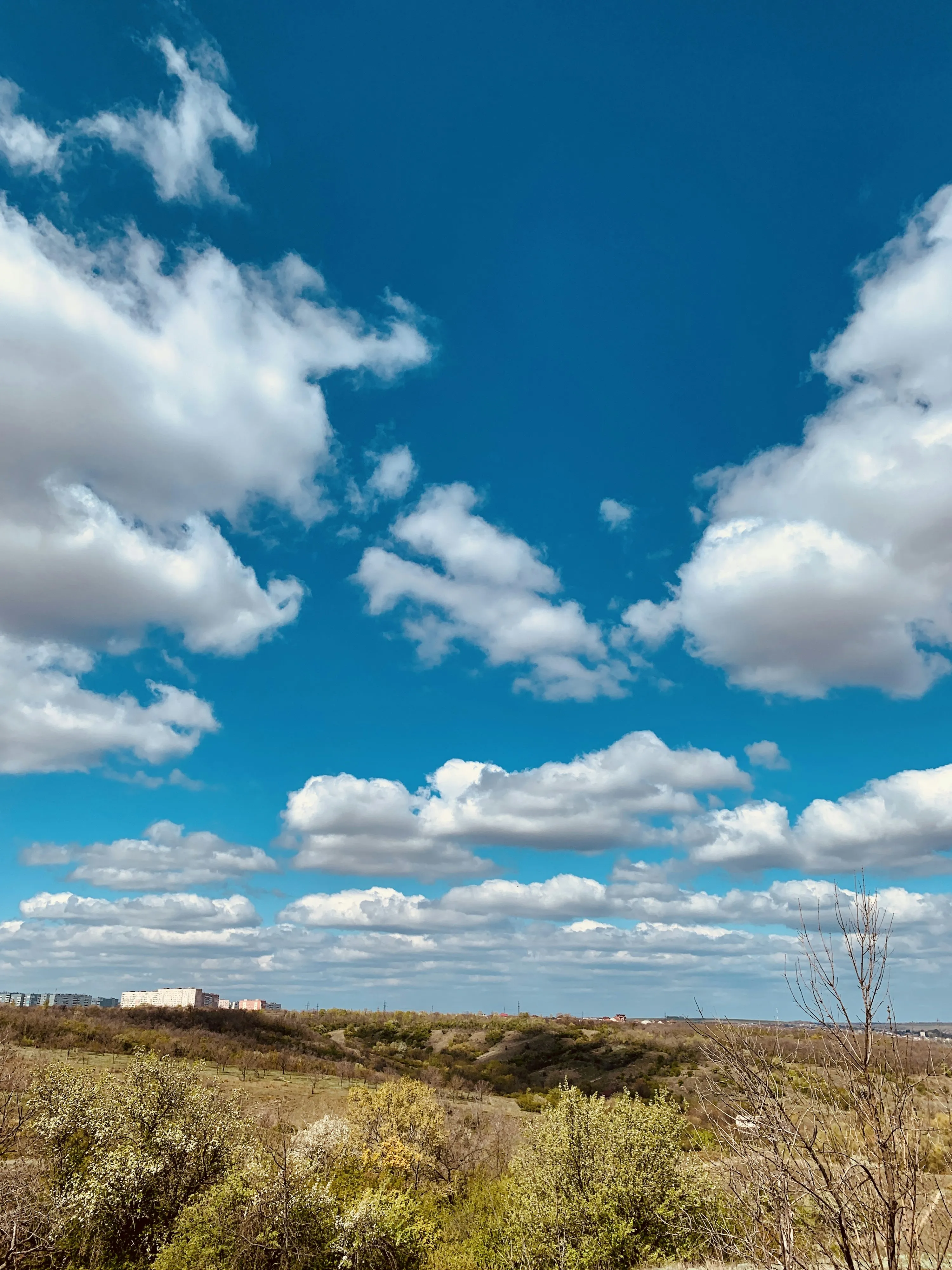 Bright Blue Sky with Puffy White Clouds Over Open Field