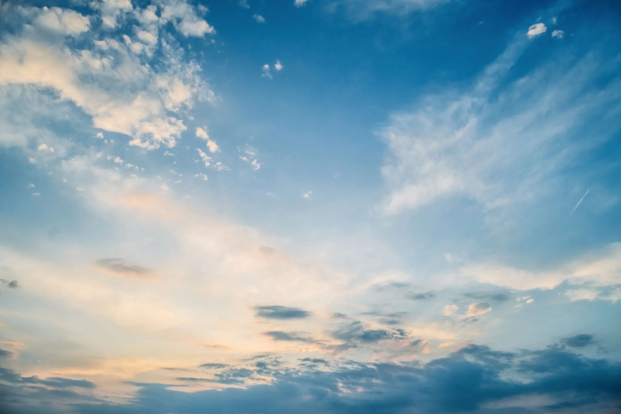 Bright Blue Sky with Scattered White Clouds and Sunlight