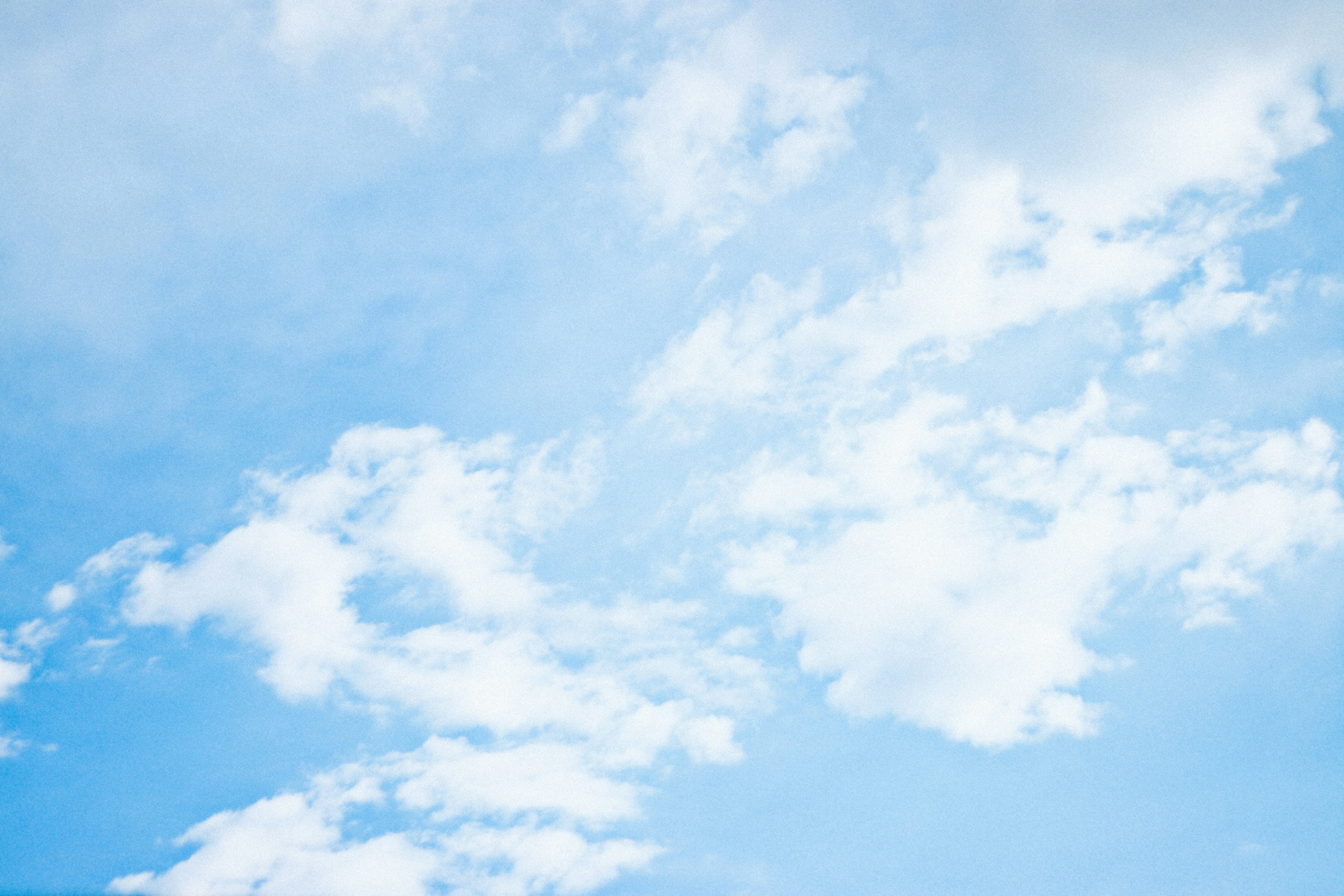 Bright Blue Sky with Scattered White Fluffy Clouds Wallpaper