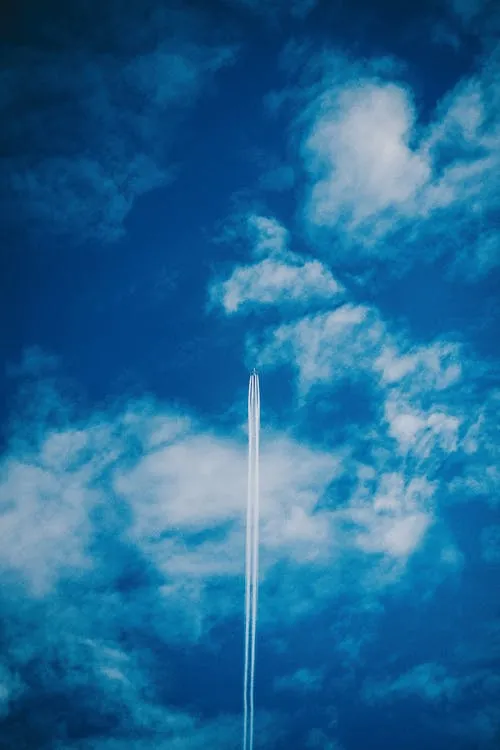 Bright Blue Sky with Tall Clouds and Jet Contrail Wallpaper