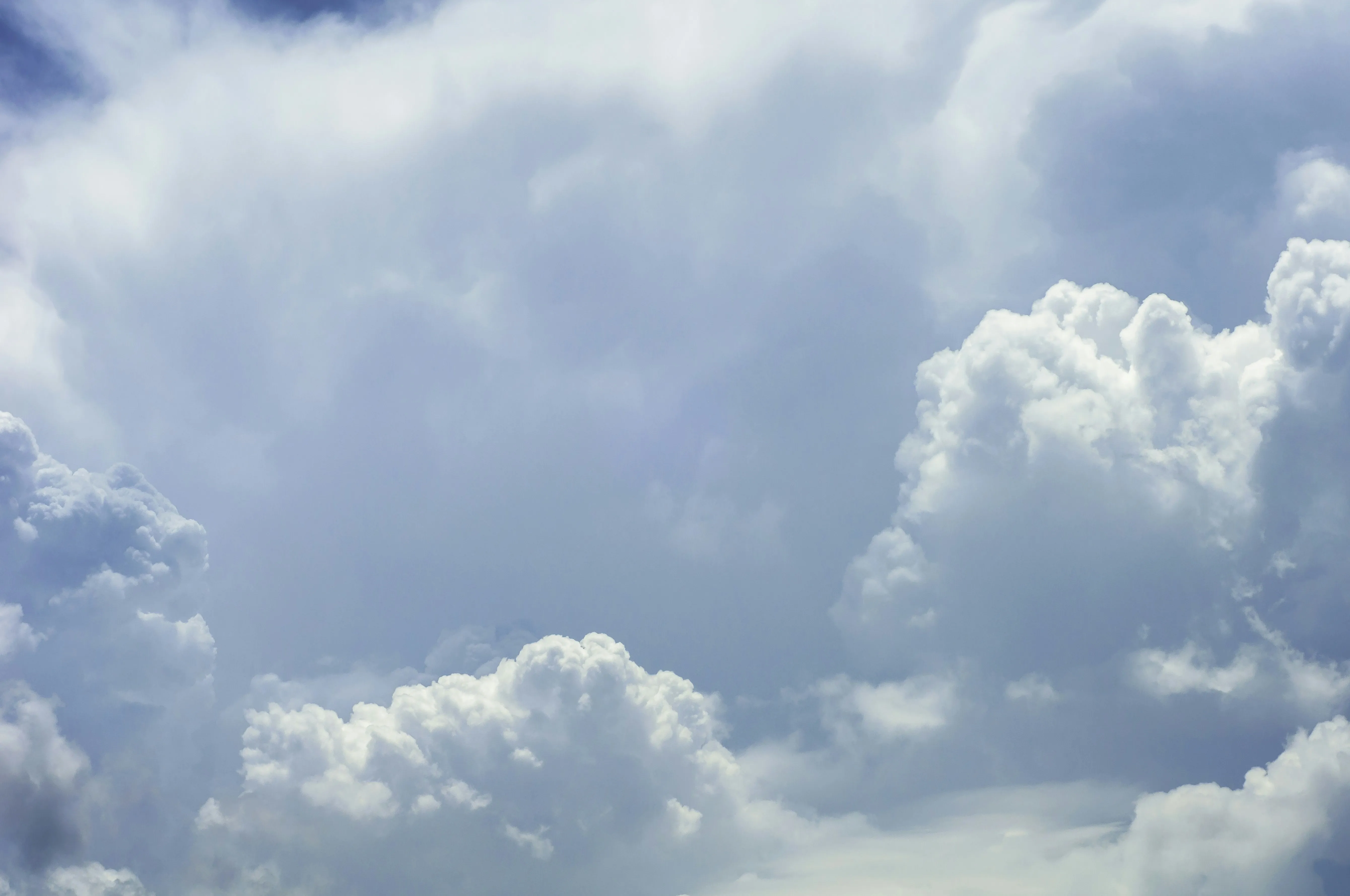Bright Blue Sky with Thick White Puffy Clouds Above Landscape
