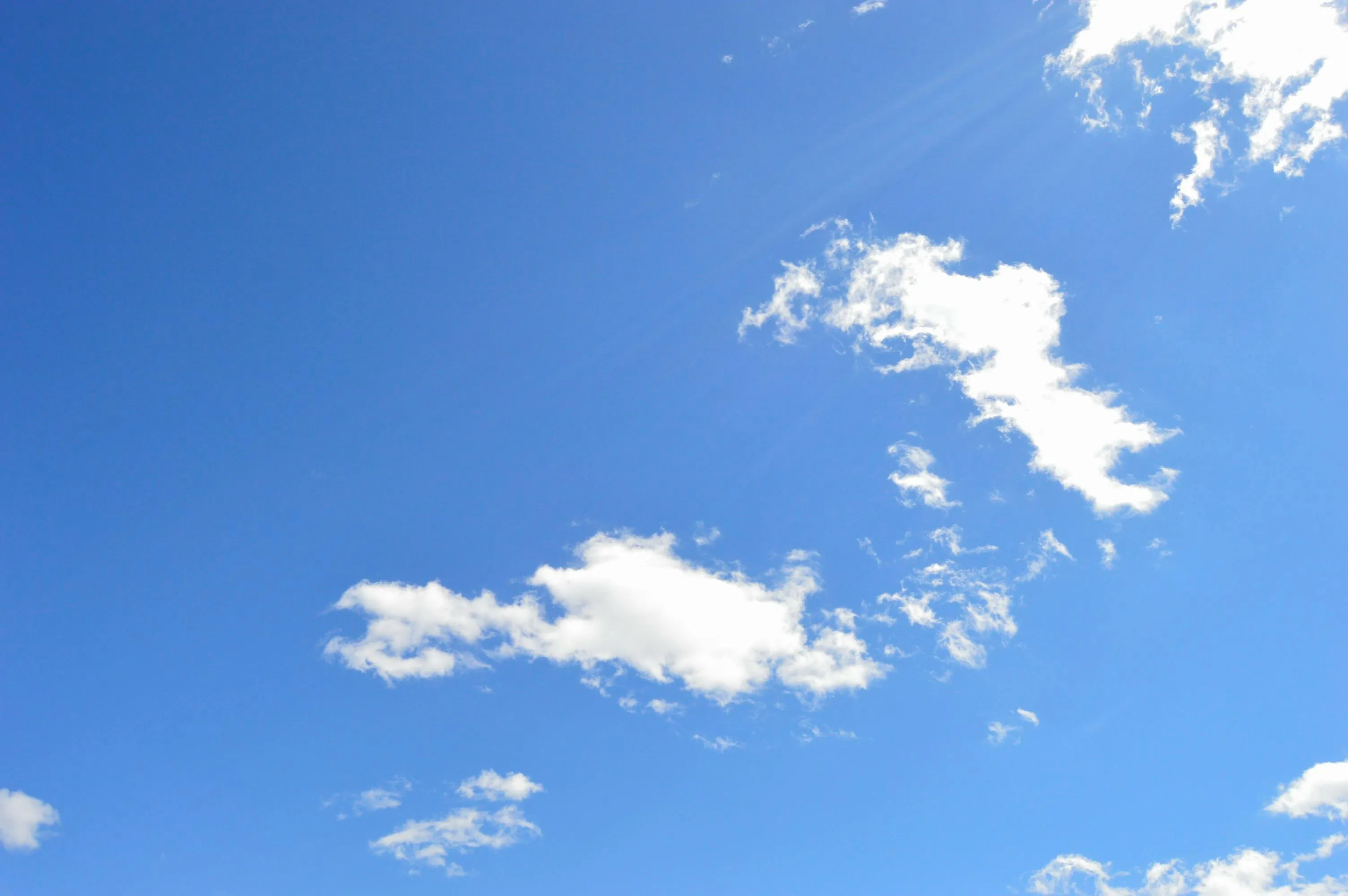 Bright Blue Sky with White Puffy Clouds and Sunshine