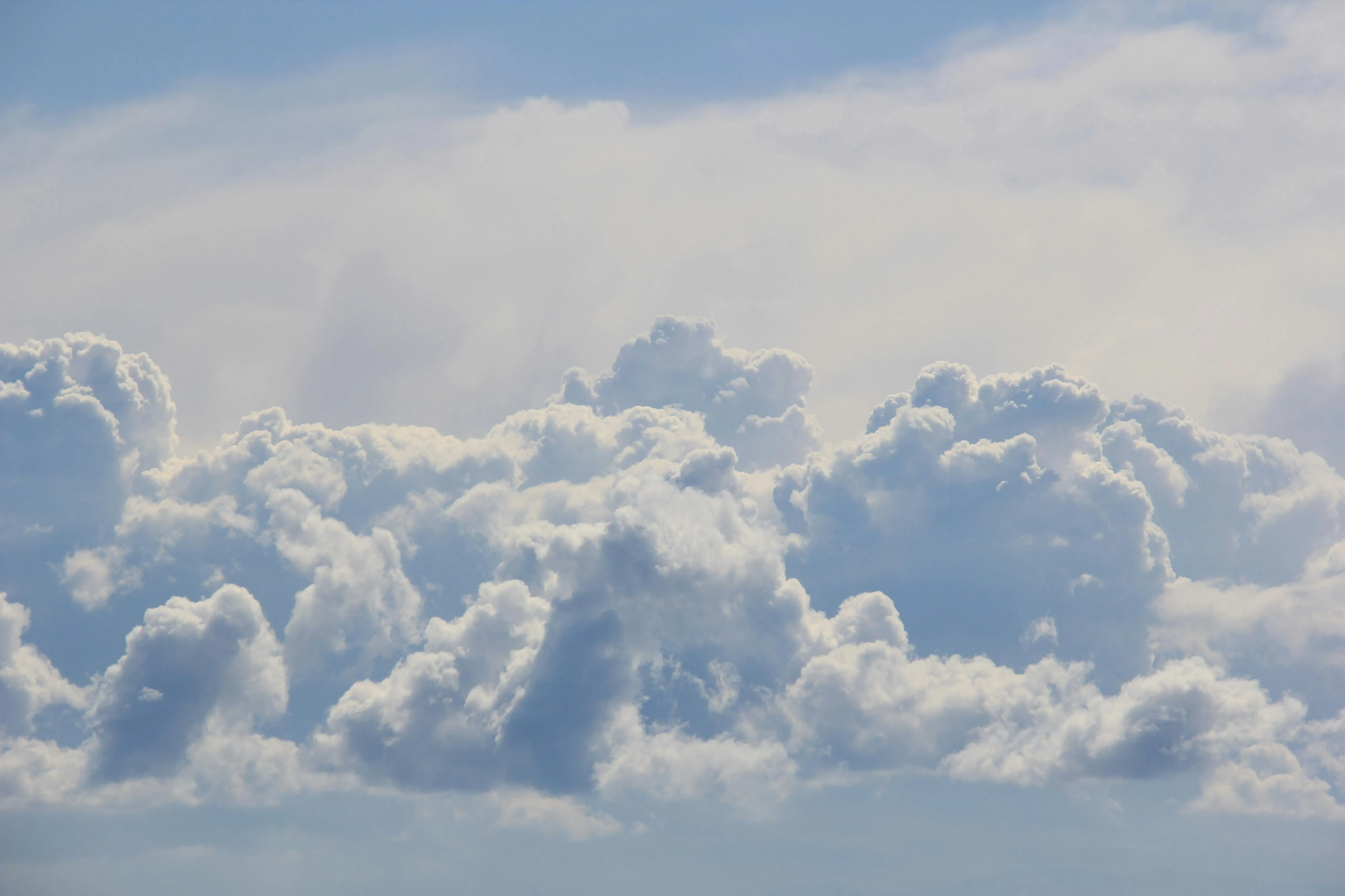 Bright Fluffy Clouds Seen From Above in Blue Sky Wallpaper