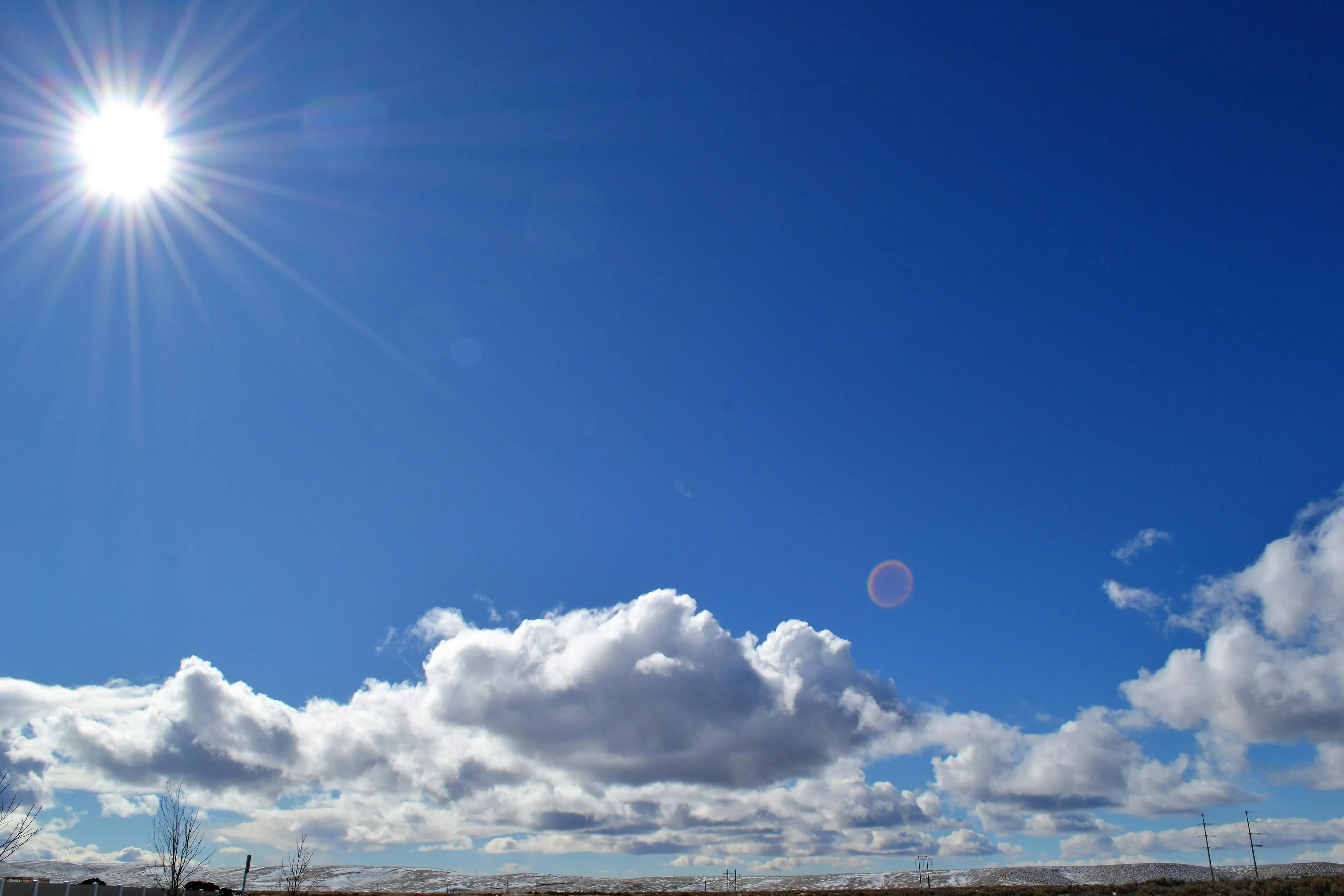 Bright Midday Sun Above Fluffy White Sky Clouds Image