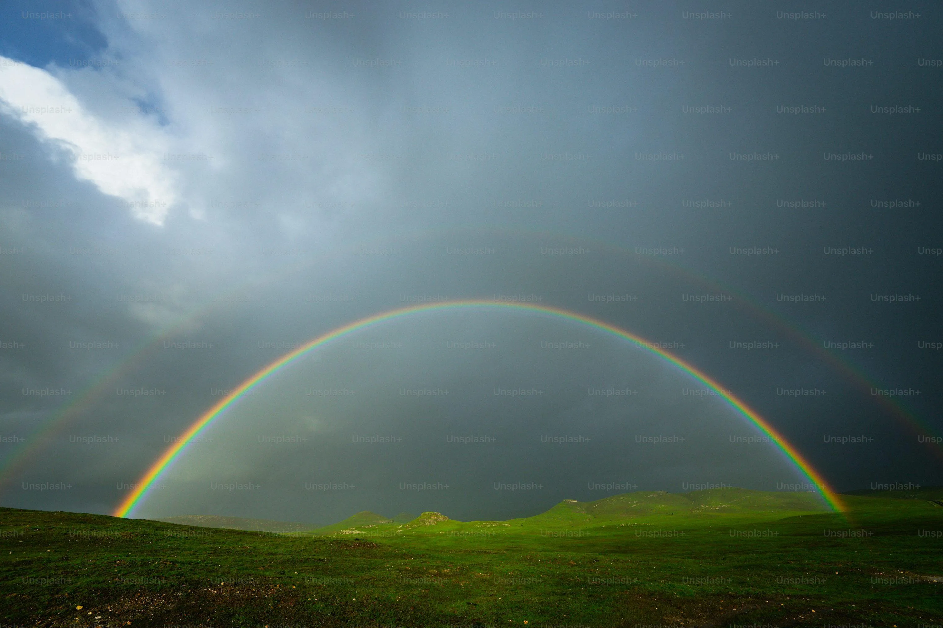 Bright Rainbow Arching Over Green Field After Rainfall