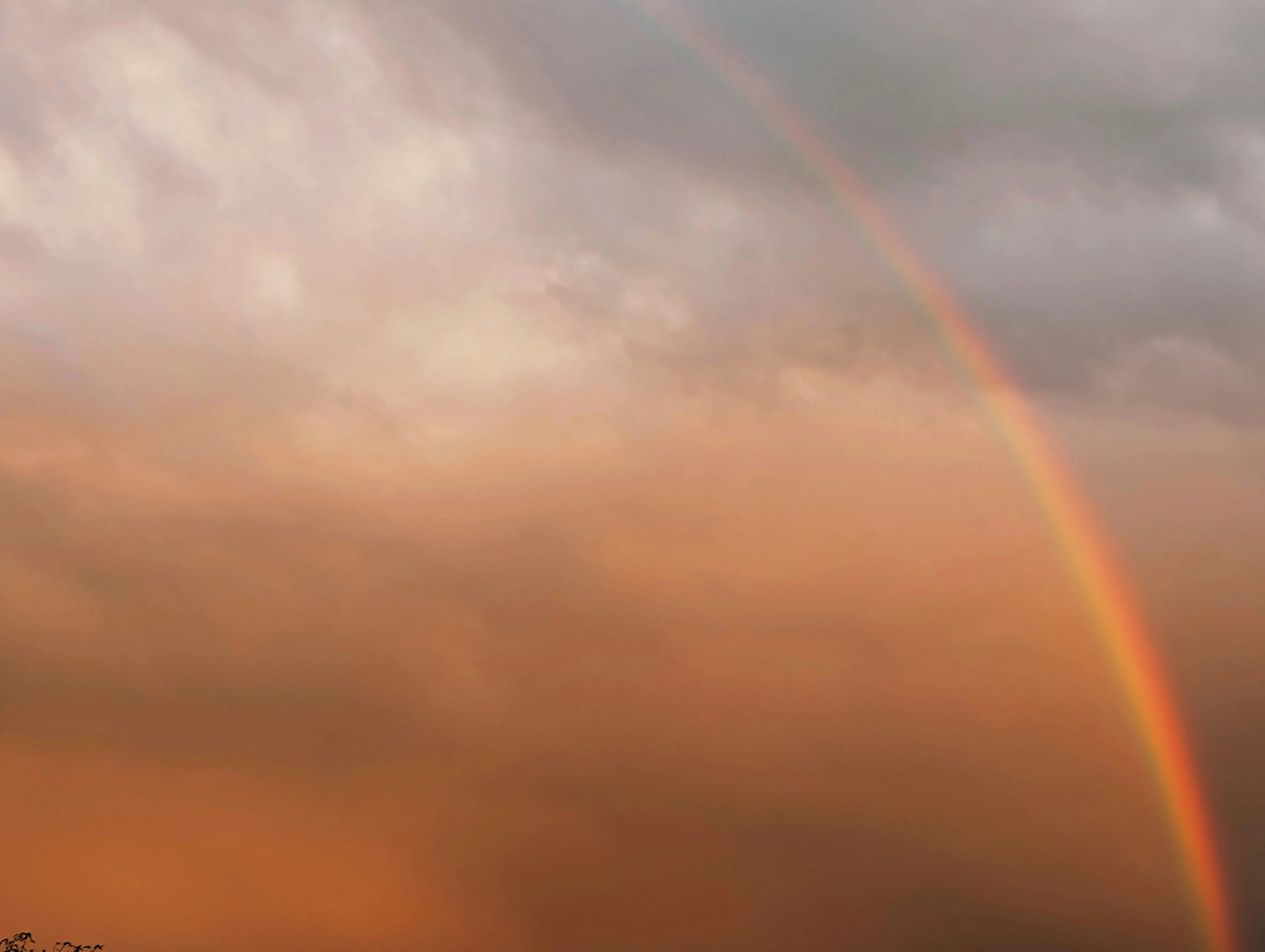 Bright Rainbow Arching Over Orange Cloudy Sky Wallpaper
