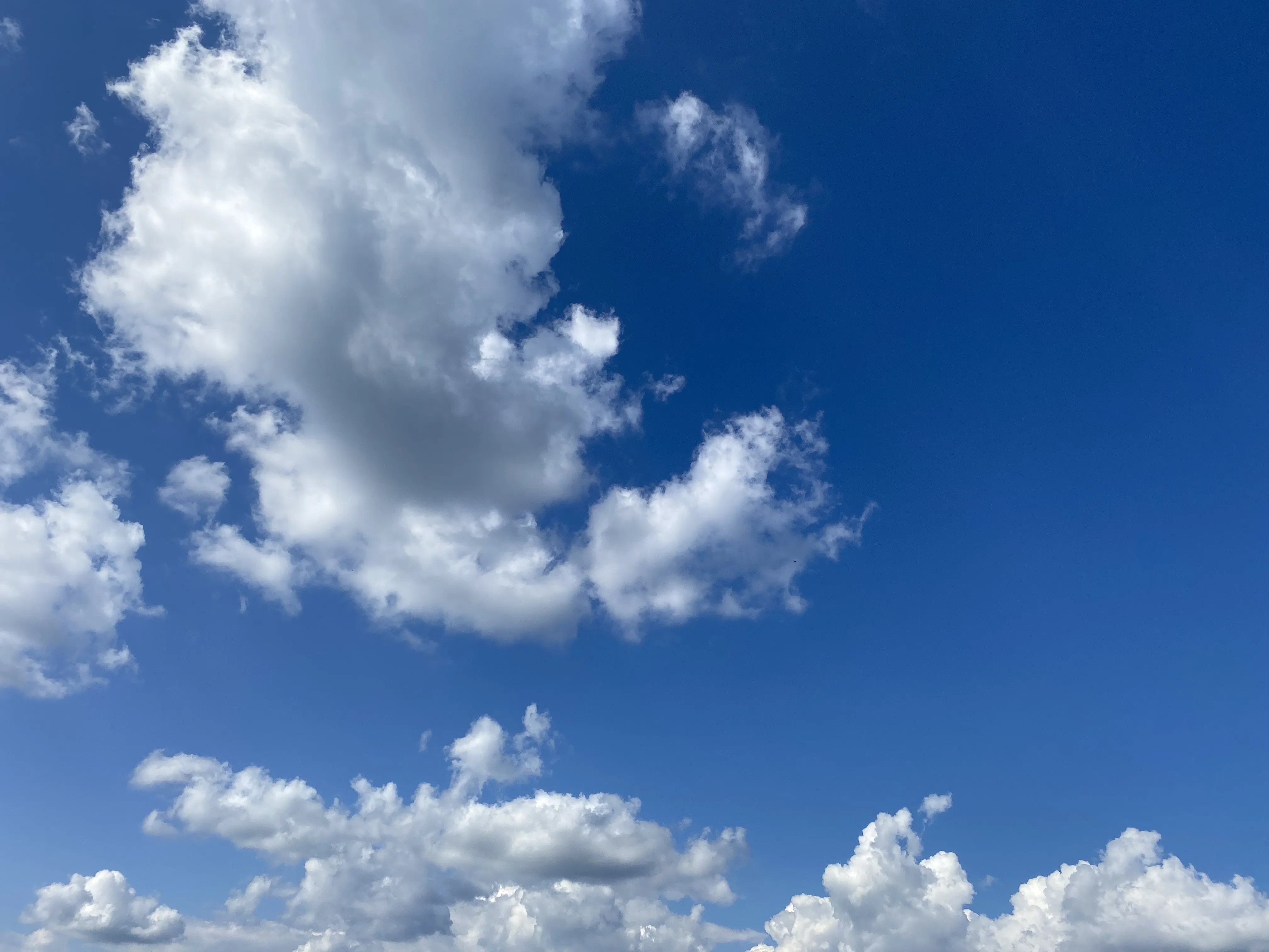 Bright White Clouds Against a Deep Blue Sky Wallpaper