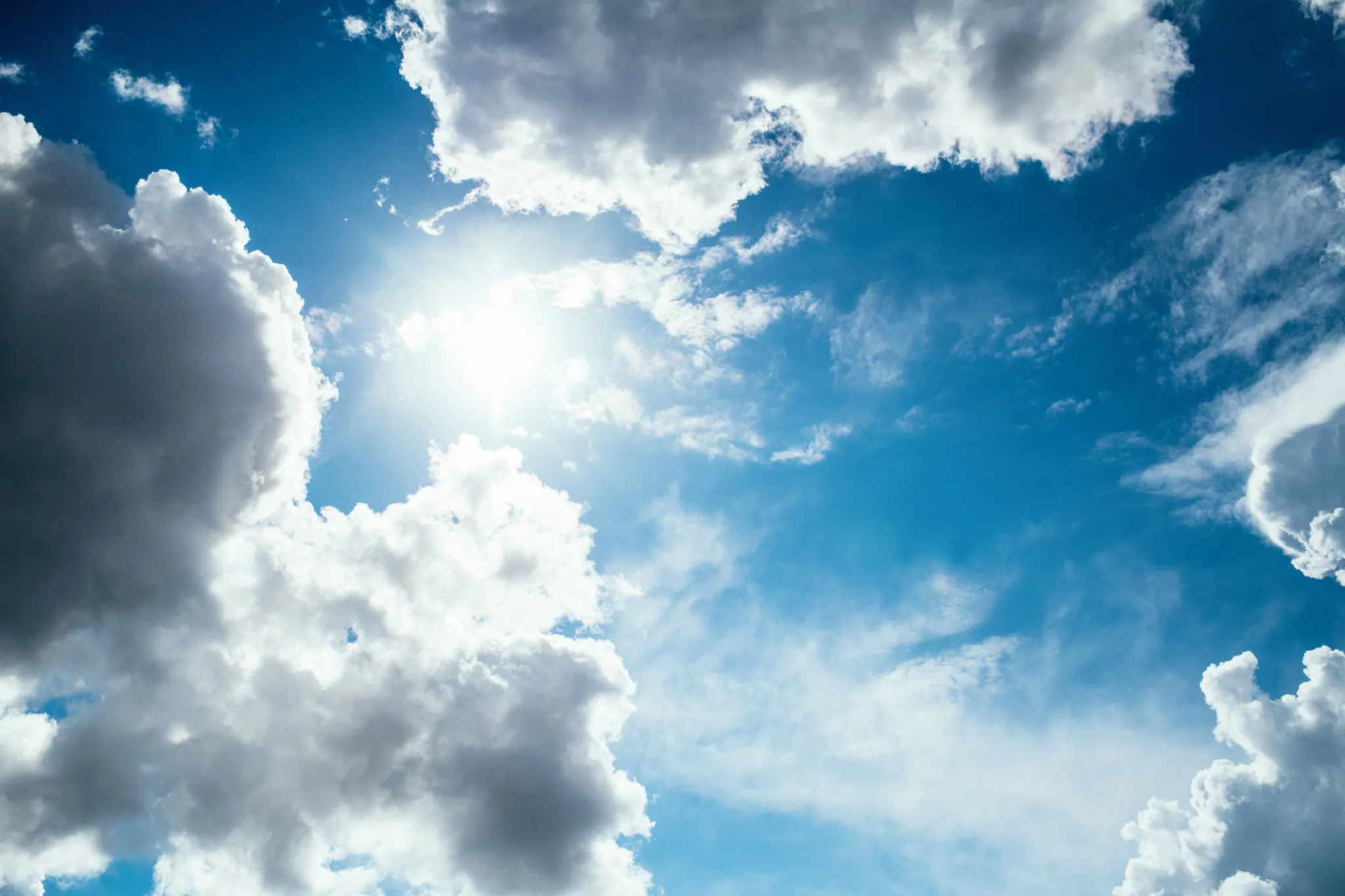 Bright White Clouds Against Vibrant Blue Sky Wallpaper