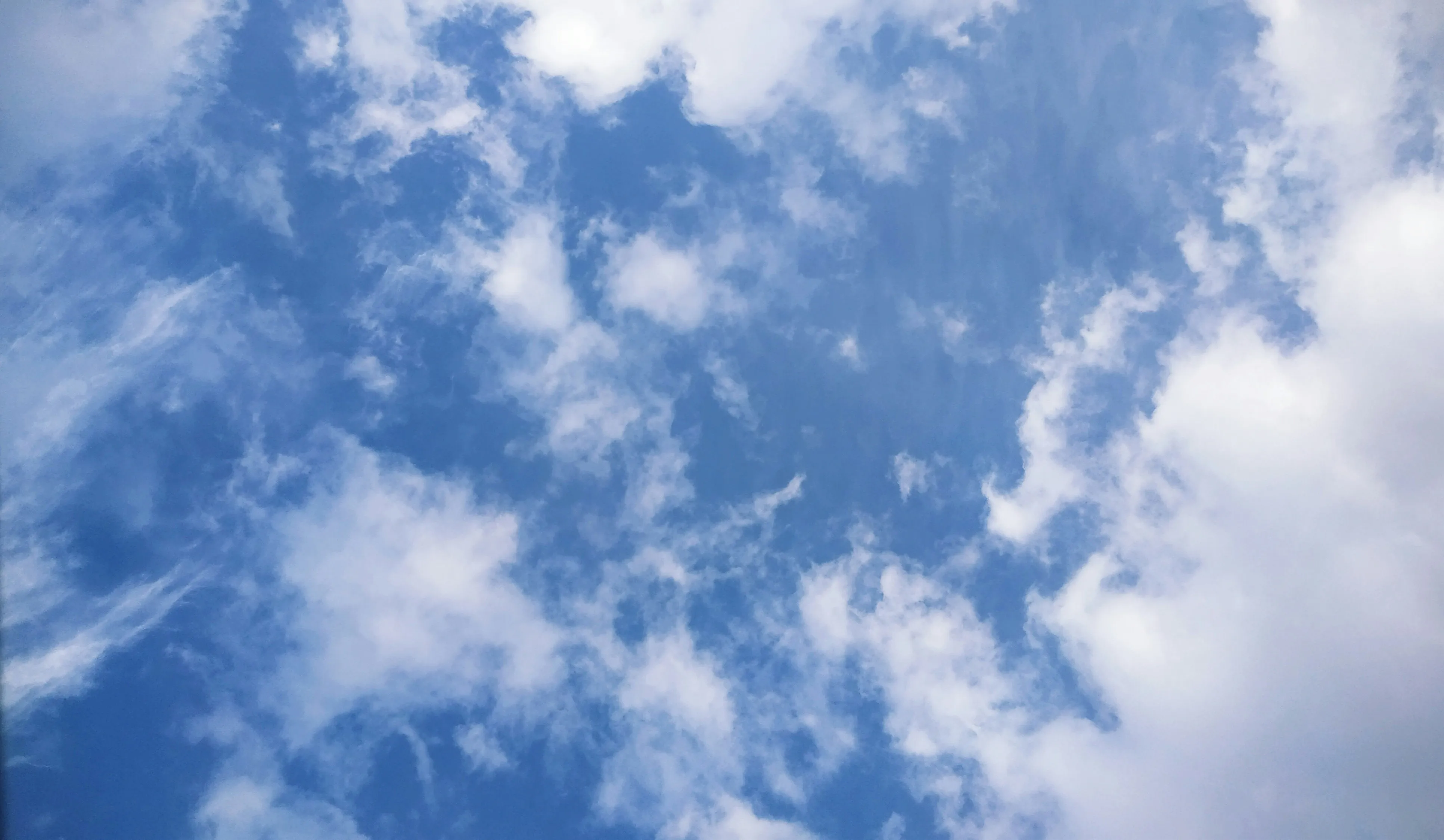 Bright White Clouds Dotting a Rich Deep Blue Sky Wallpaper