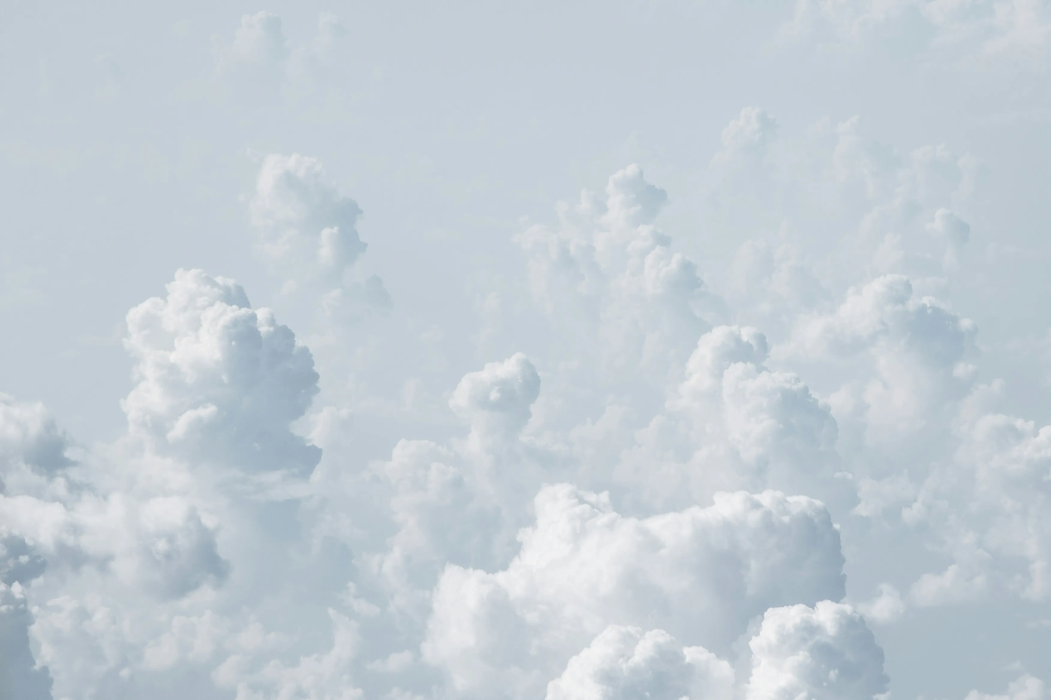 Bright White Clouds Floating in a Clear Blue Sky Wallpaper