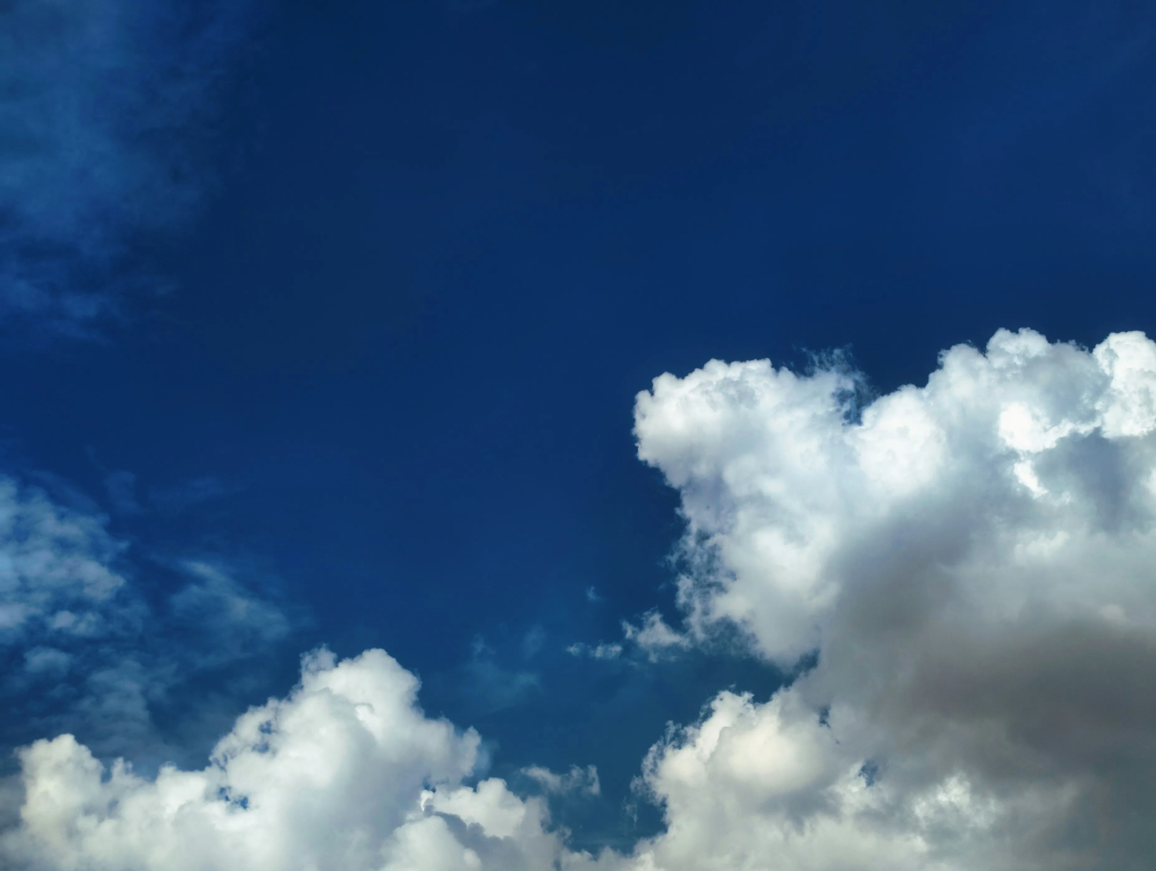 Bright White Clouds Floating in Deep Blue Sky Wallpaper